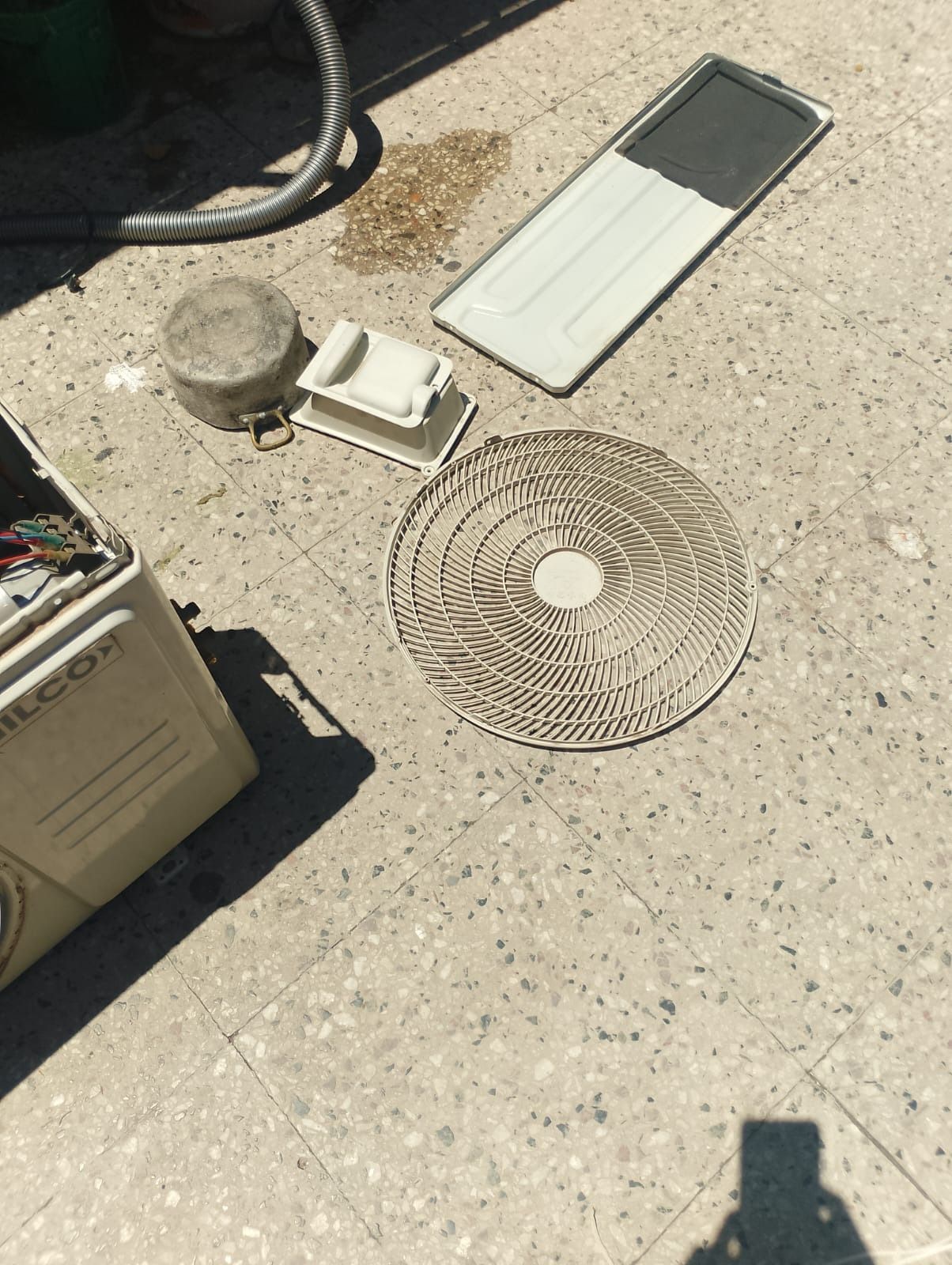 Lavadora con piezas desmontadas sobre una superficie de hormigón.