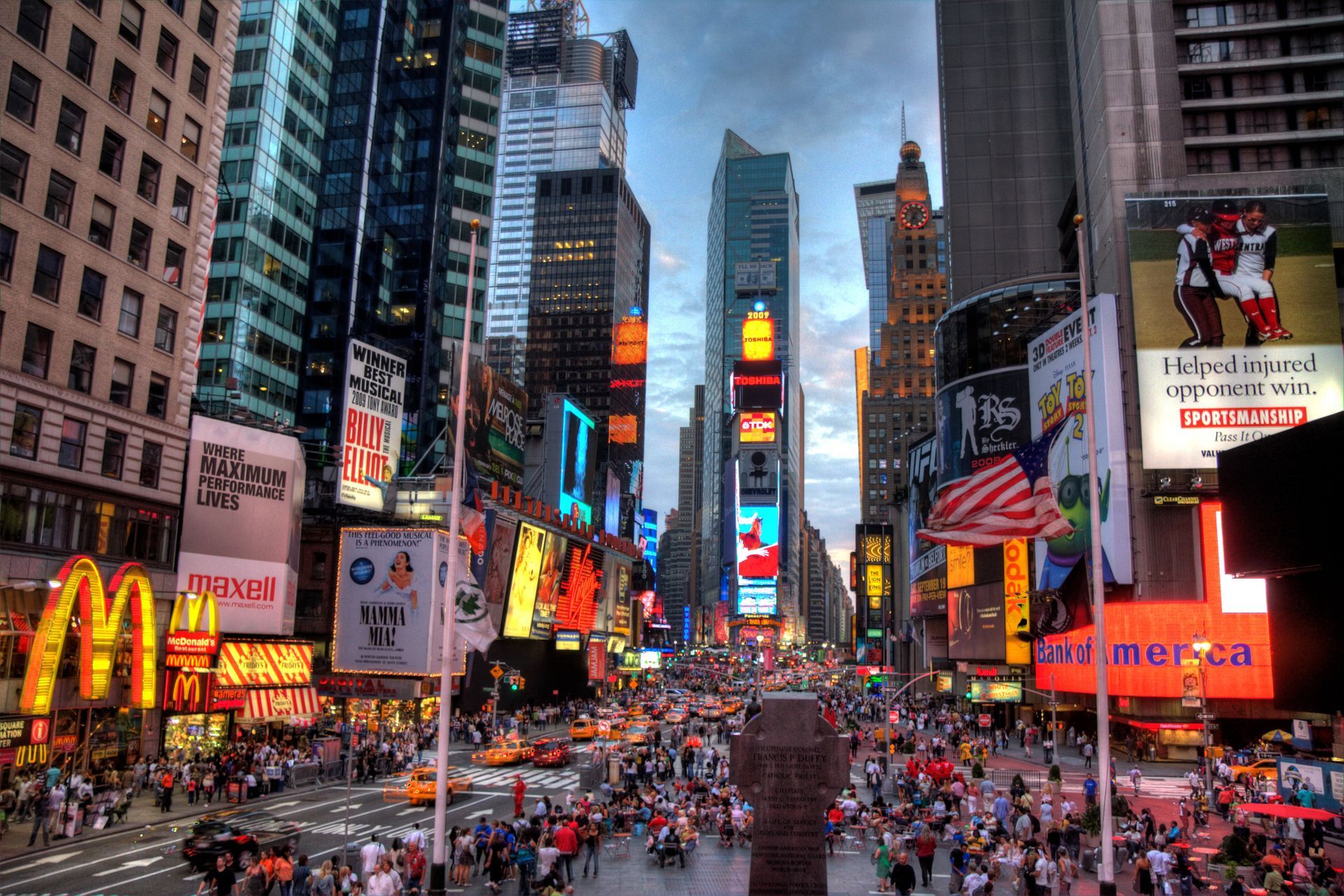 A busy city street with a mcdonald 's in the middle