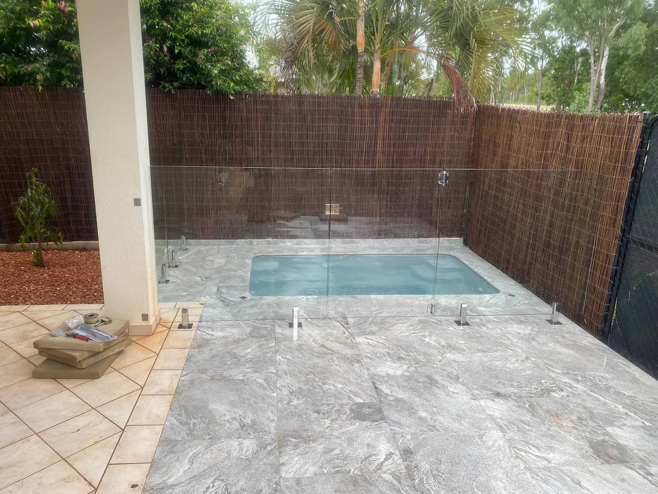 A Swimming Pool With a Glass Fence in a Backyard — Pooltech NT In Alawa, NT
