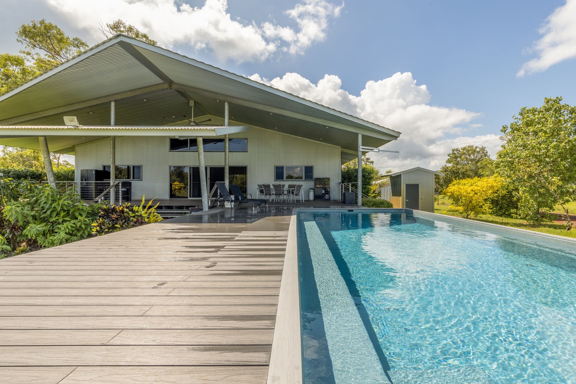 A Large White House with A Swimming Pool in Front of It — Pooltech NT In Alawa, NT