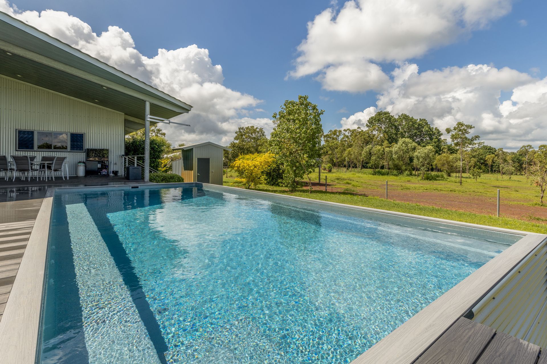 There Is a Large Swimming Pool in The Backyard of A House — Pooltech NT In Alawa, NT
