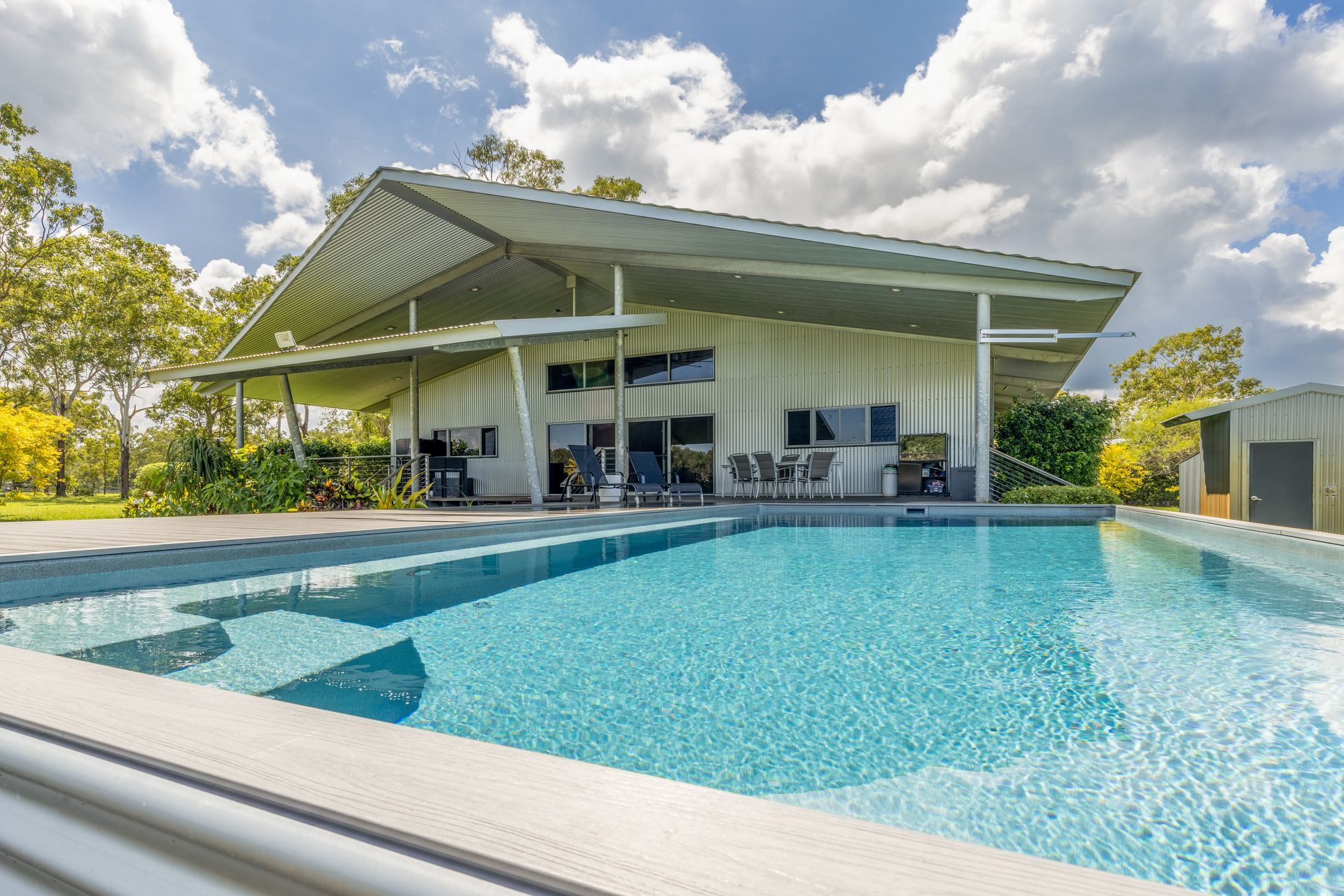 A Large House with A Swimming Pool in Front of It — Pooltech NT In Alawa, NT