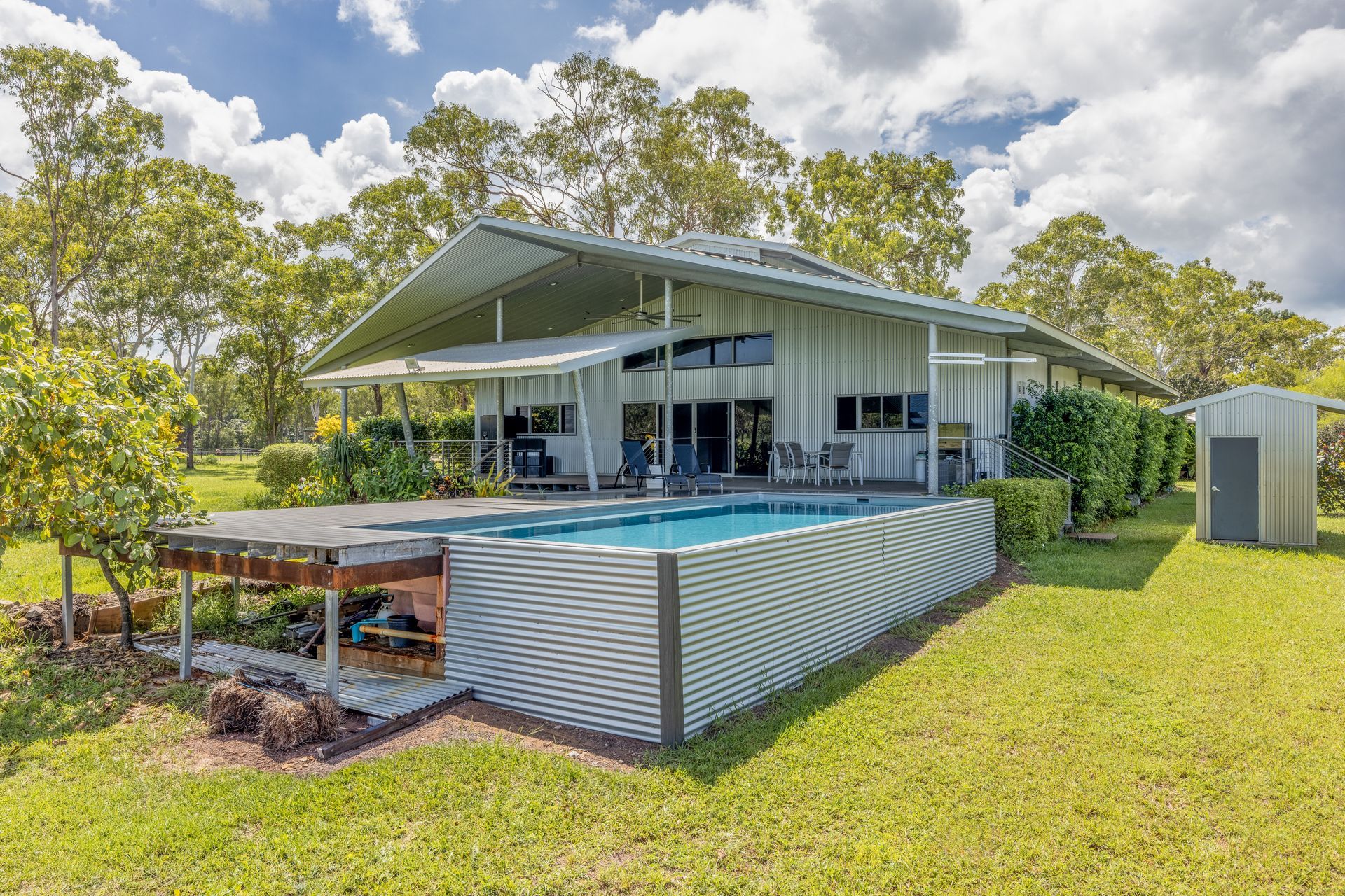 A Large White House with A Swimming Pool in The Backyard — Pooltech NT In Alawa, NT