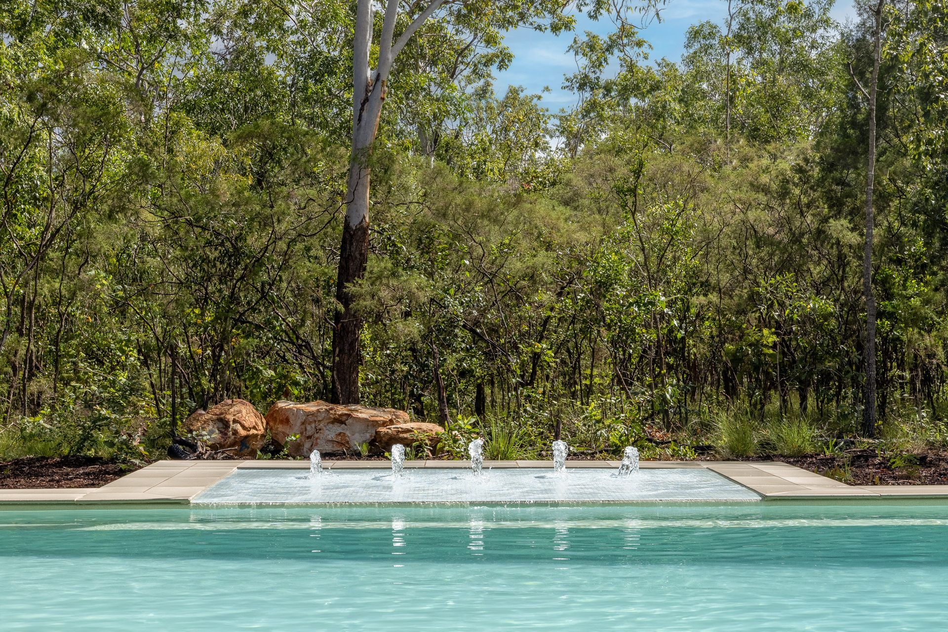 A Large Swimming Pool with A Fountain in The Middle of It Surrounded by Trees — Pooltech NT In Alawa, NT