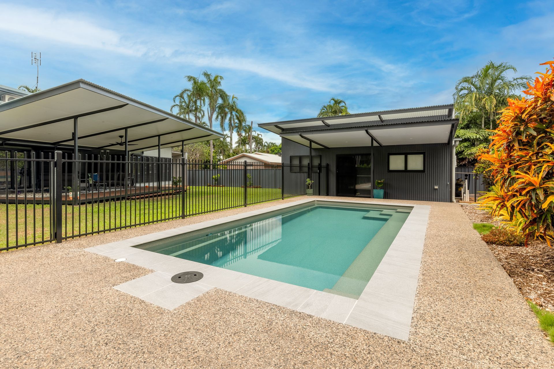 A Large Swimming Pool Is in The Backyard of A House — Pooltech NT In Alawa, NT