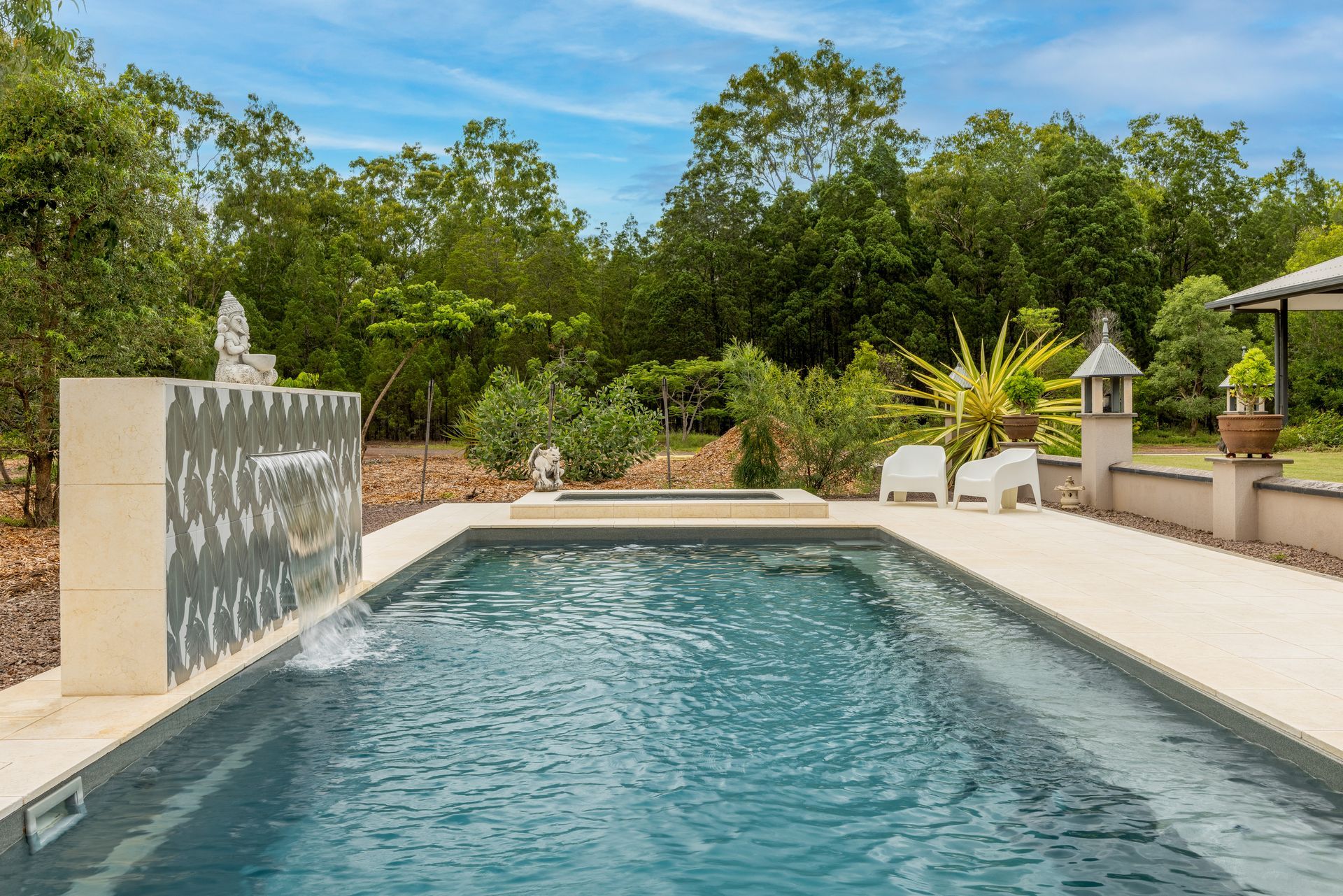 A Large Swimming Pool With a Waterfall in the Background — Pooltech NT In Alawa, NT