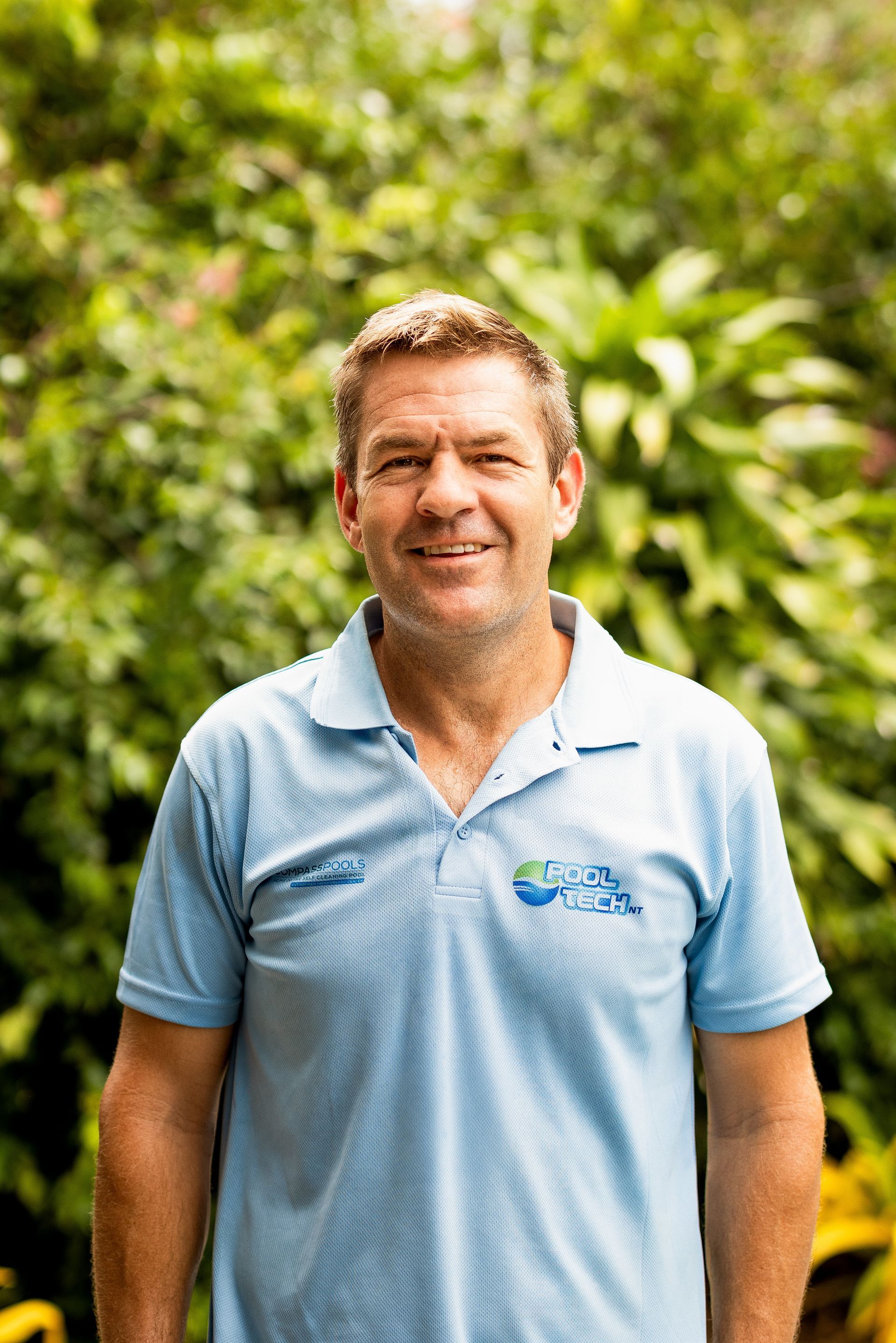 A Man in A Blue Shirt Is Standing in Front of A Bush — Pooltech NT In Alawa, NT