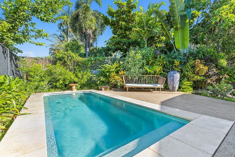 A Large Swimming Pool Surrounded by Trees and Bushes in a Backyard — Pooltech NT In Alawa, NT