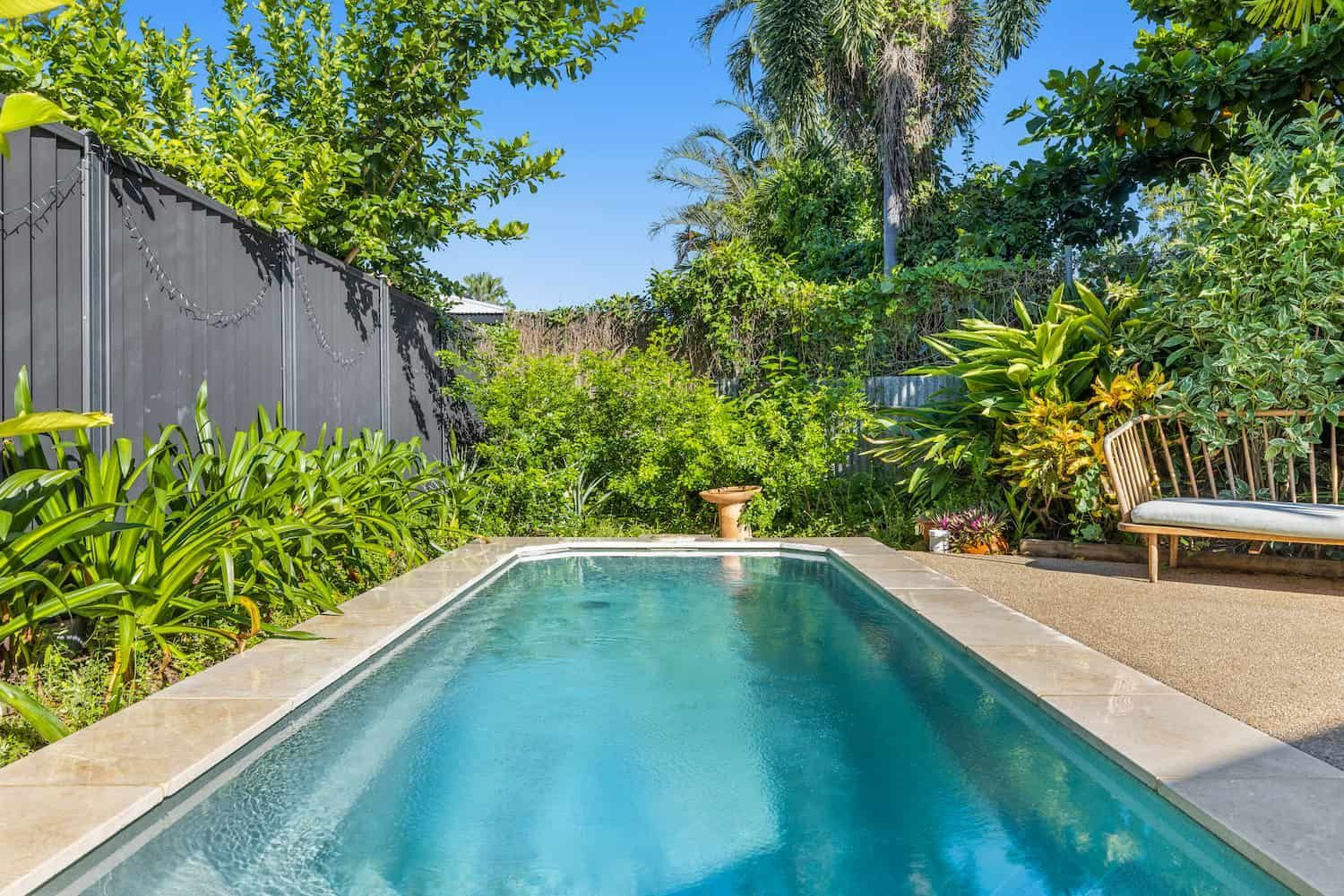 A Large Swimming Pool in the Backyard of a House Surrounded by Trees and Bushes — Pooltech NT In Alawa, NT