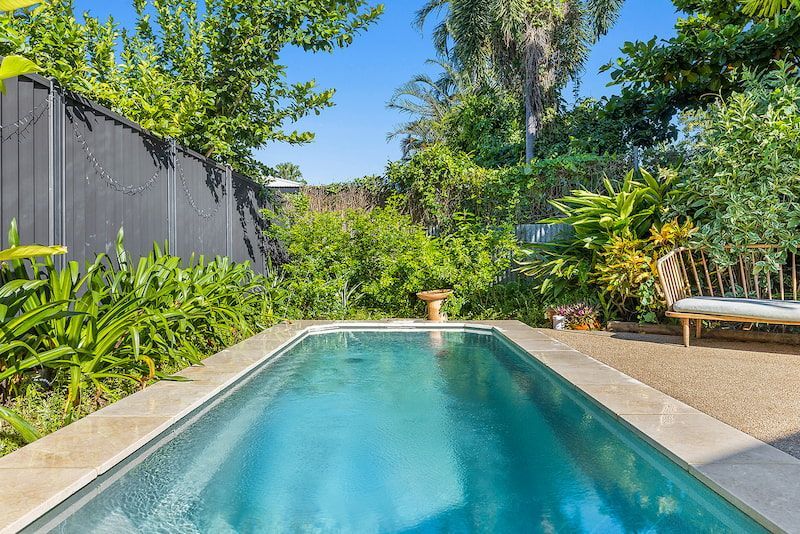 A Large Swimming Pool in the Backyard of a House Surrounded by Trees and Bushes — Pooltech NT In Alawa, NT