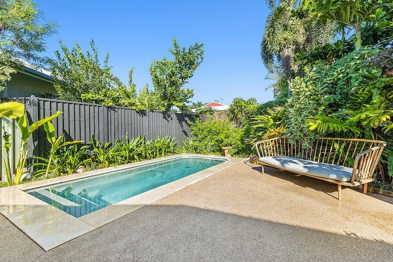 There is a Swimming Pool in the Backyard With a Couch — Pooltech NT In Alawa, NT