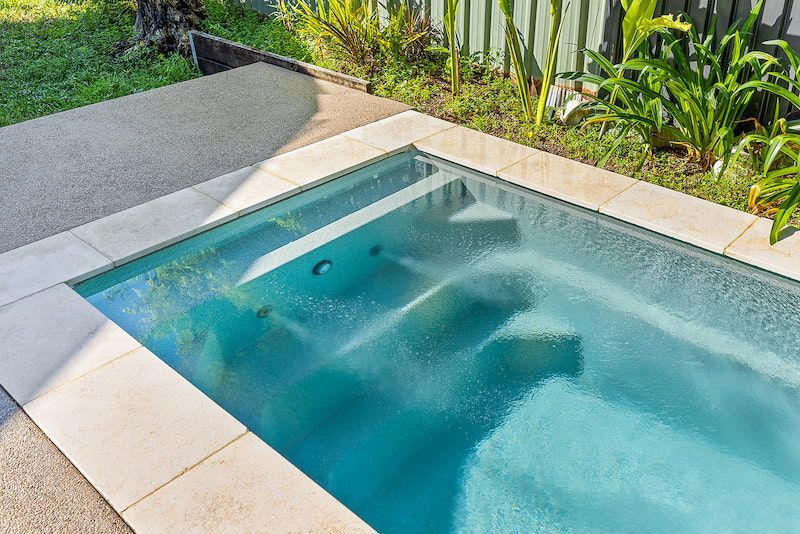 There is a Swimming Pool in the Backyard With a Couch — Pooltech NT In Alawa, NT