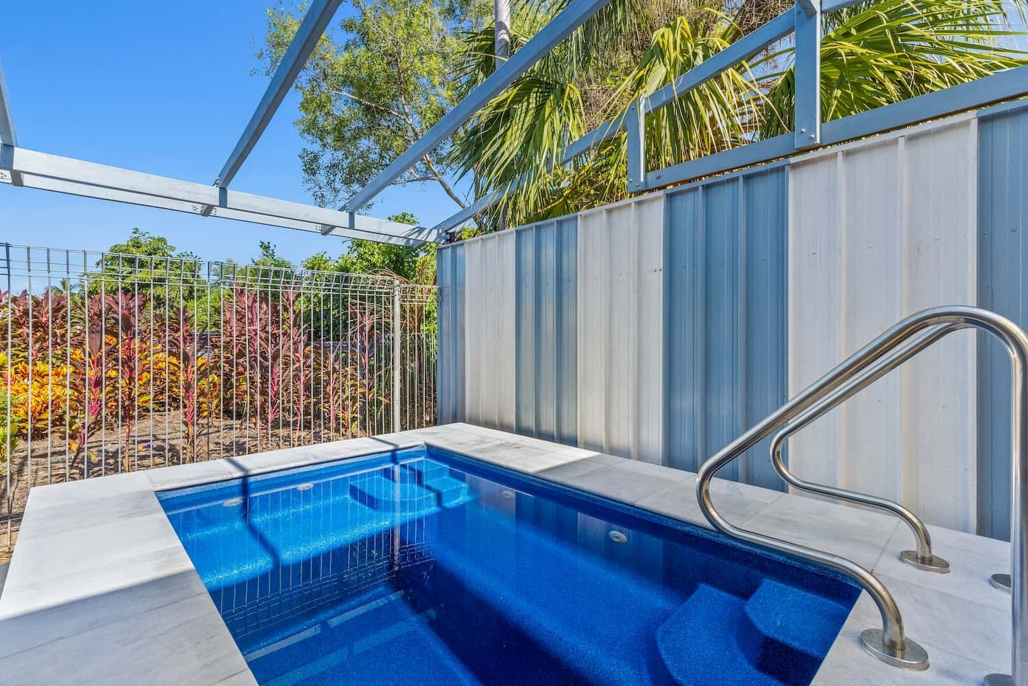 A Small Swimming Pool With Stairs Leading to It is Surrounded by a White Fence — Pooltech NT In Alawa, NT