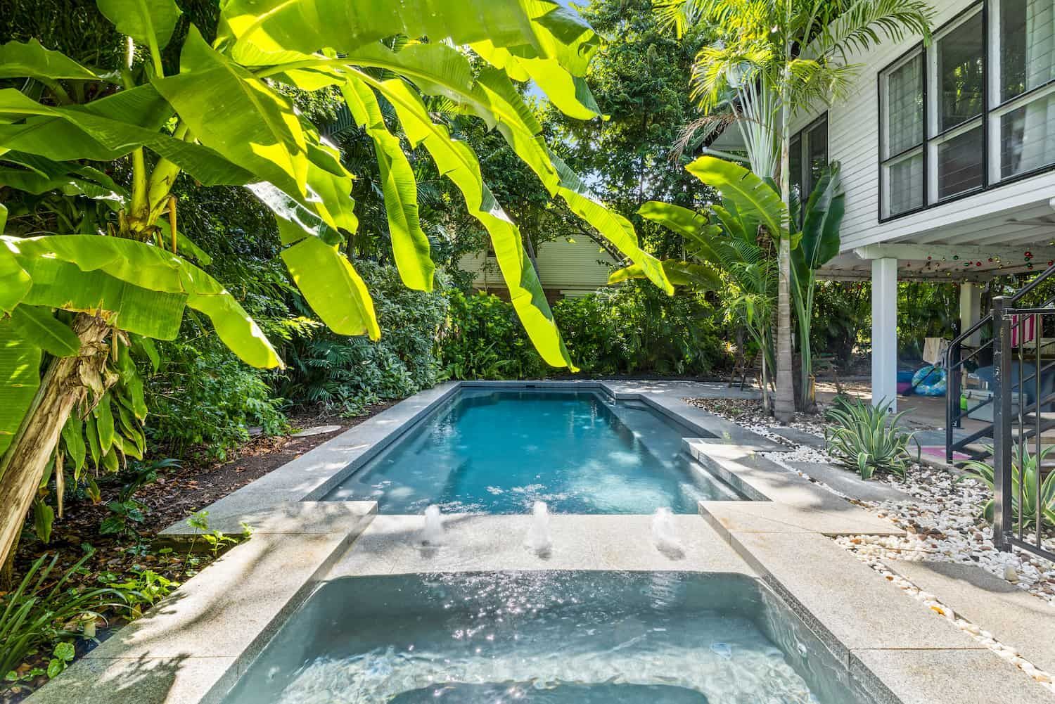 There is a Large Swimming Pool in the Backyard of a House Surrounded by Trees — Pooltech NT In Alawa, NT