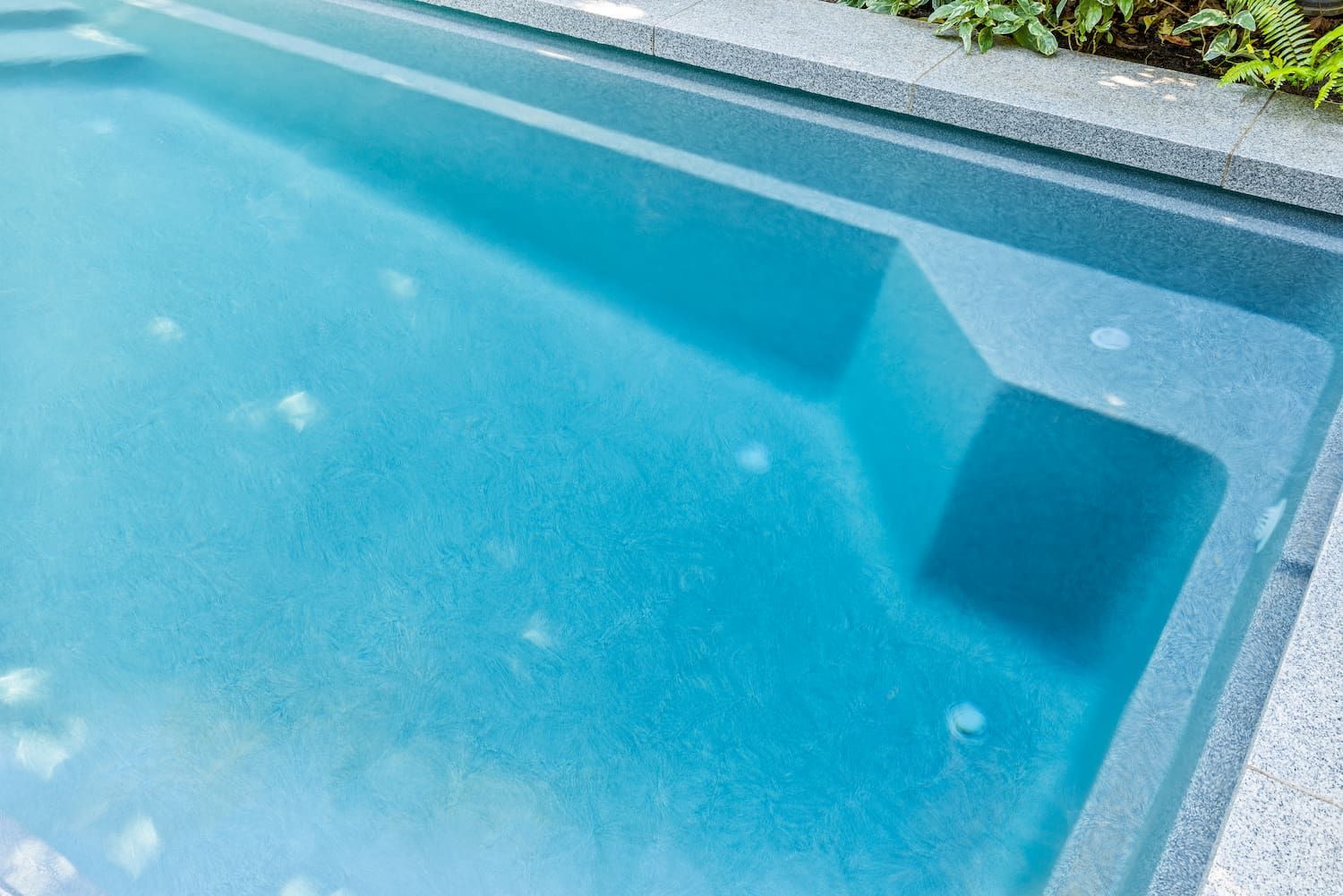 A Swimming Pool With Blue Water and Steps in a Backyard — Pooltech NT In Alawa, NT