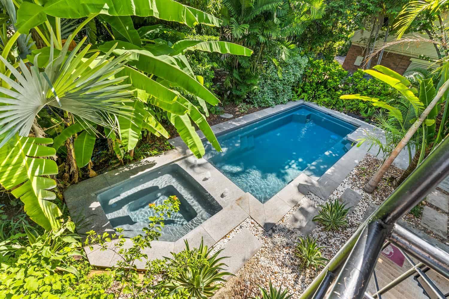 A Large Swimming Pool in the Middle of a Lush Green Garden Surrounded by Trees — Pooltech NT In Alawa, NT