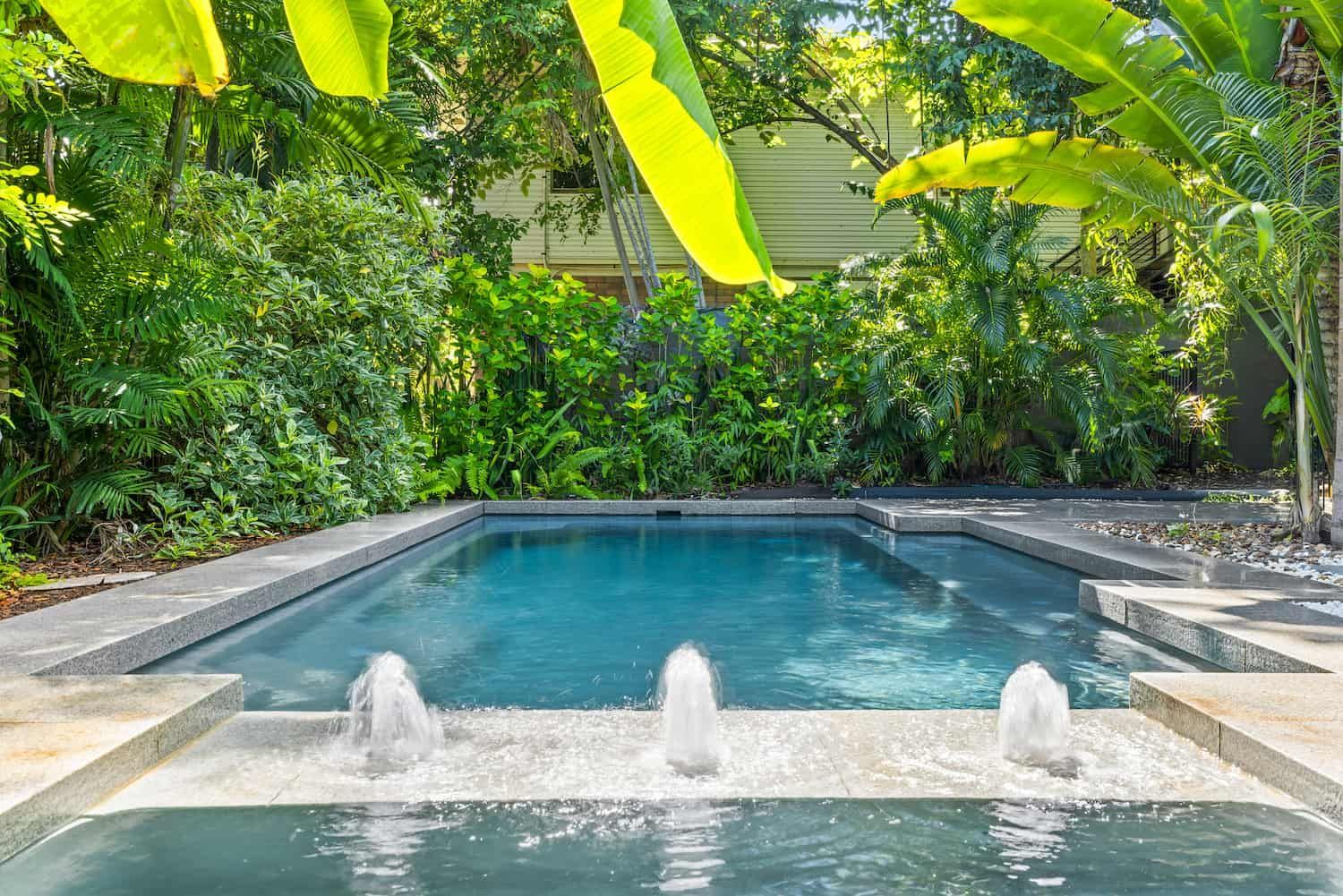 A Large Swimming Pool With Three Fountains in the Middle of It Surrounded by Trees — Pooltech NT In Alawa, NT