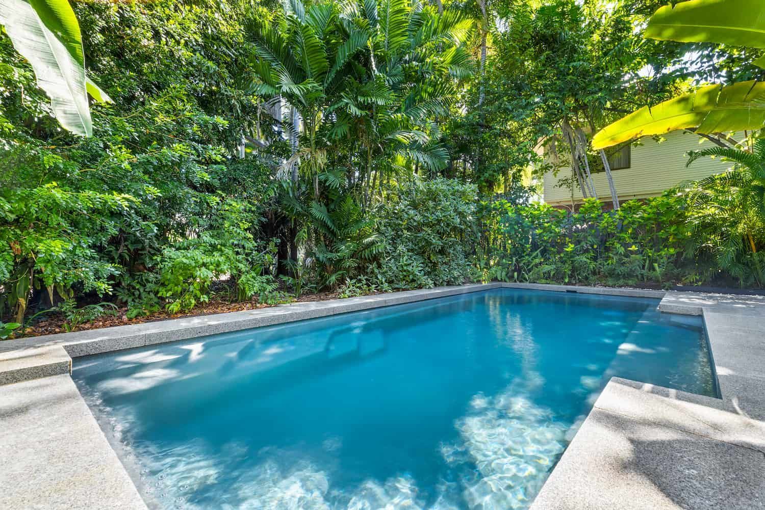 A Large Swimming Pool Surrounded by Trees and Bushes — Pooltech NT In Alawa, NT