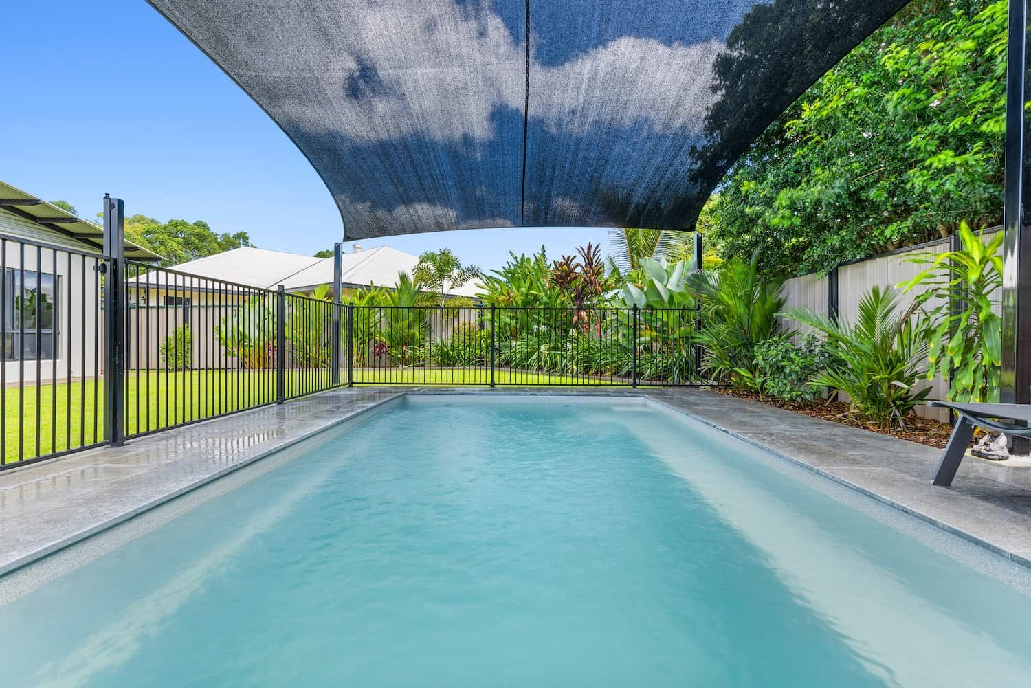 A Large Swimming Pool With a Blue Umbrella Over It — Pooltech NT In Alawa, NT