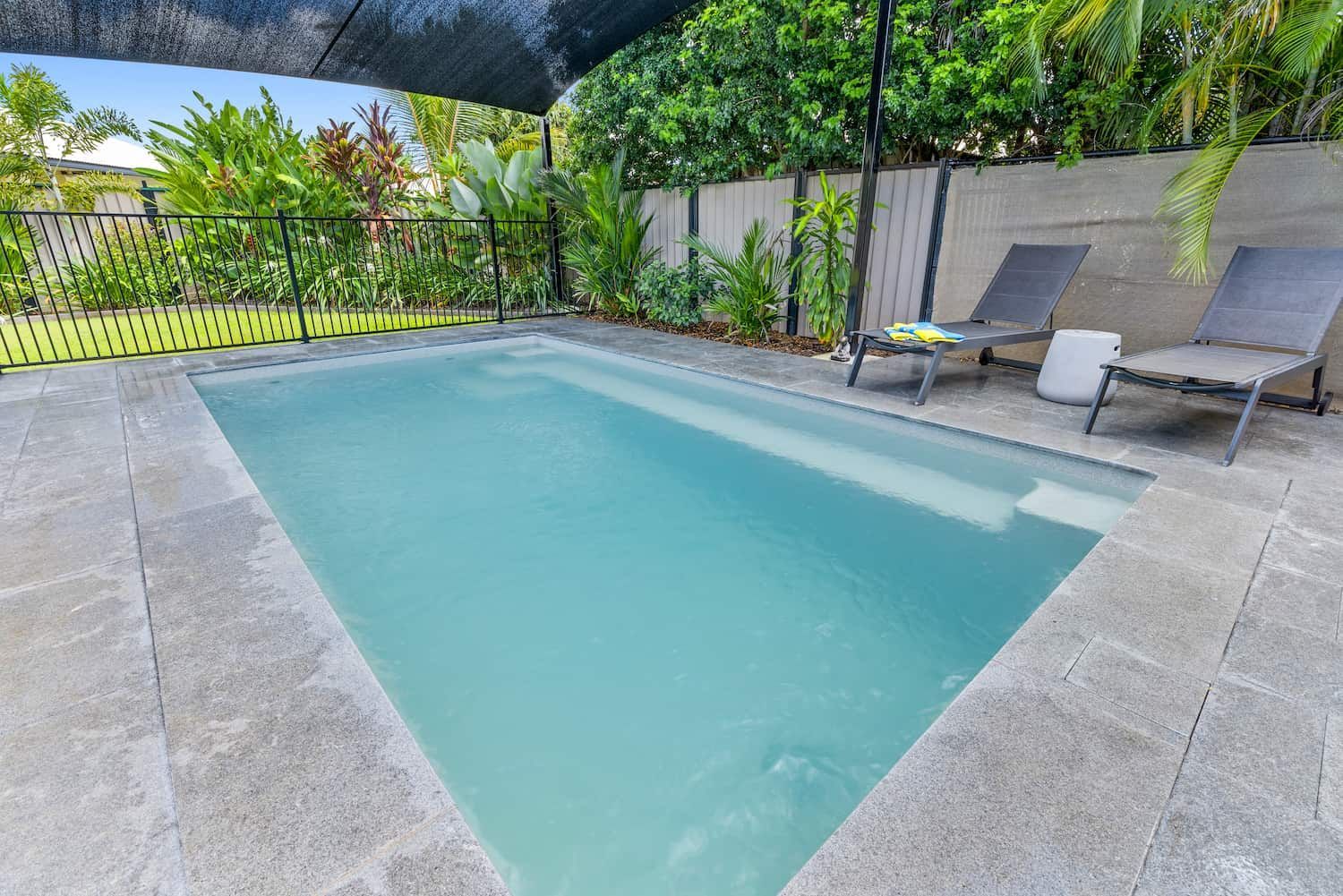 A Swimming Pool With Chairs and Umbrellas Around It — Pooltech NT In Alawa, NT