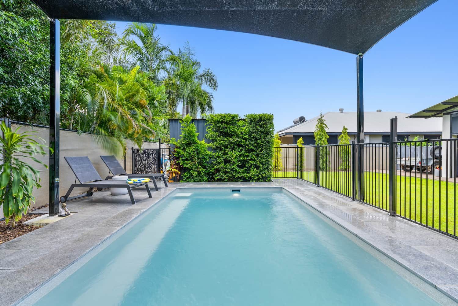 A Large Swimming Pool is Surrounded by Chairs and a Fence — Pooltech NT In Alawa, NT