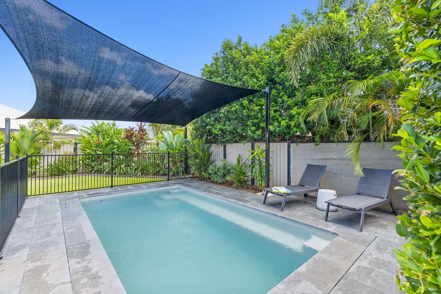 A Large Swimming Pool With a Black Umbrella Over It — Pooltech NT In Alawa, NT