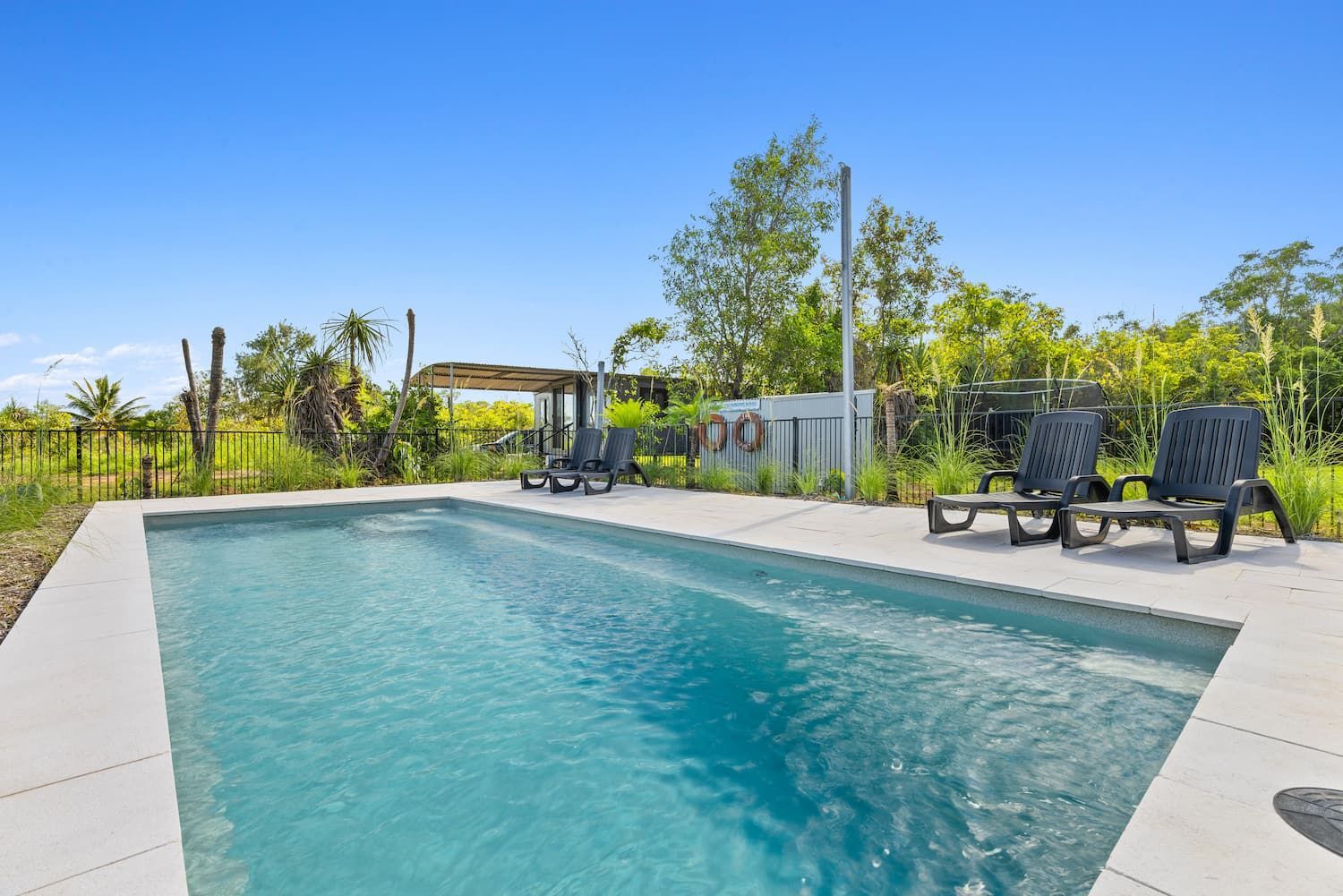 There is a Large Swimming Pool With Chairs Around It — Pooltech NT In Alawa, NT
