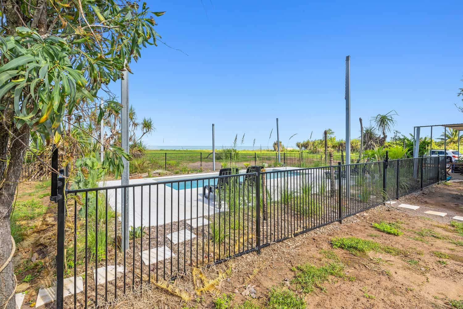 A Fence Surrounds a Swimming Pool in a Yard — Pooltech NT In Alawa, NT