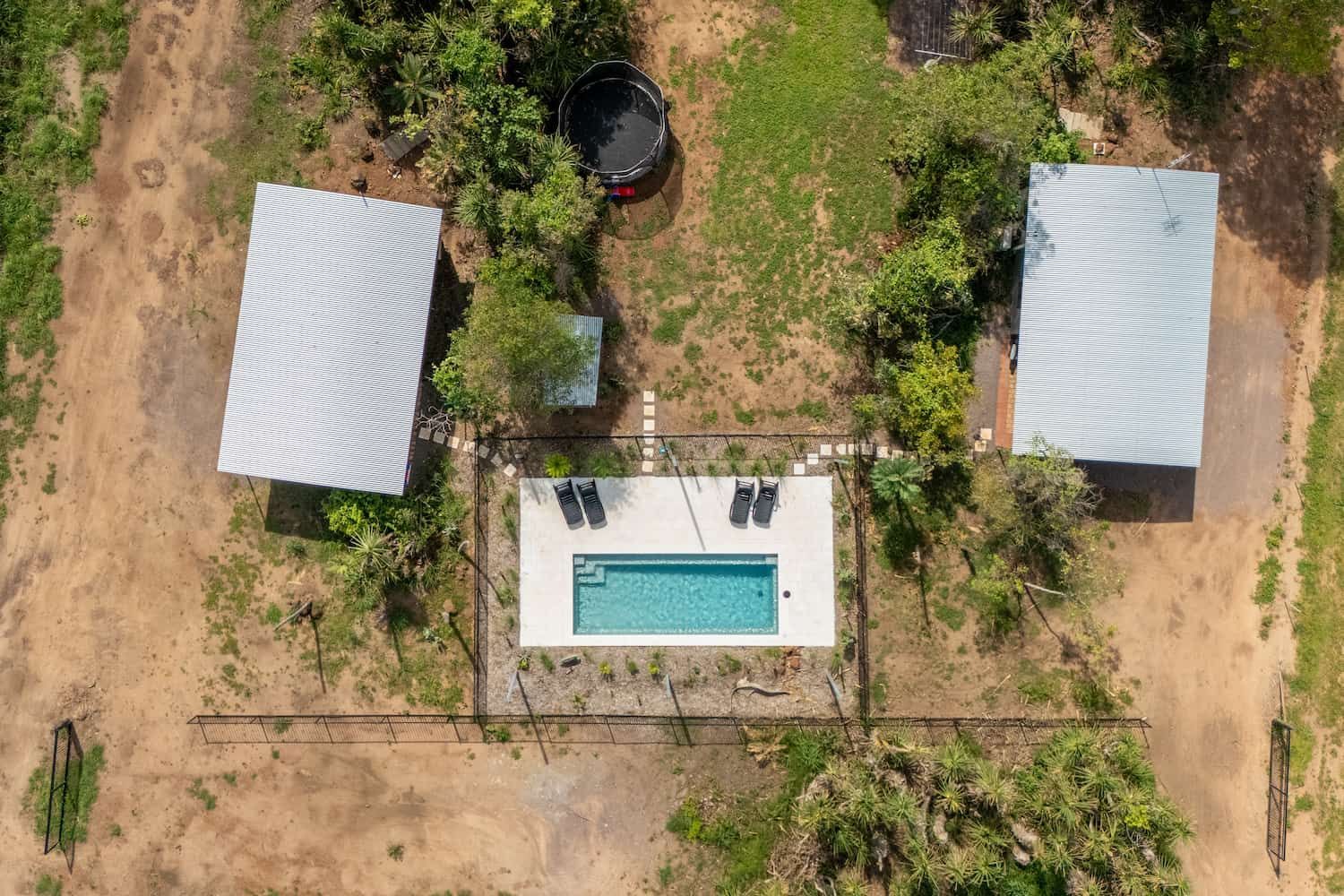 An Aerial View of a Swimming Pool Surrounded by Trees and Houses — Pooltech NT In Alawa, NT