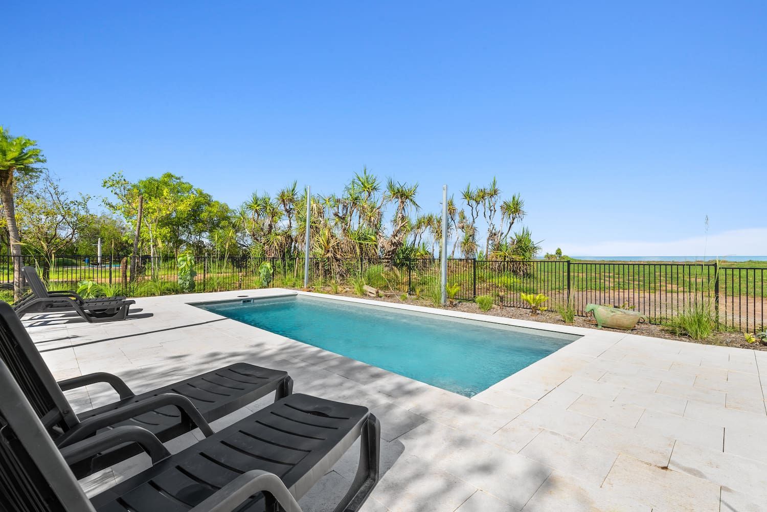 There is a Large Swimming Pool in the Backyard With Chairs Around It — Pooltech NT In Alawa, NT