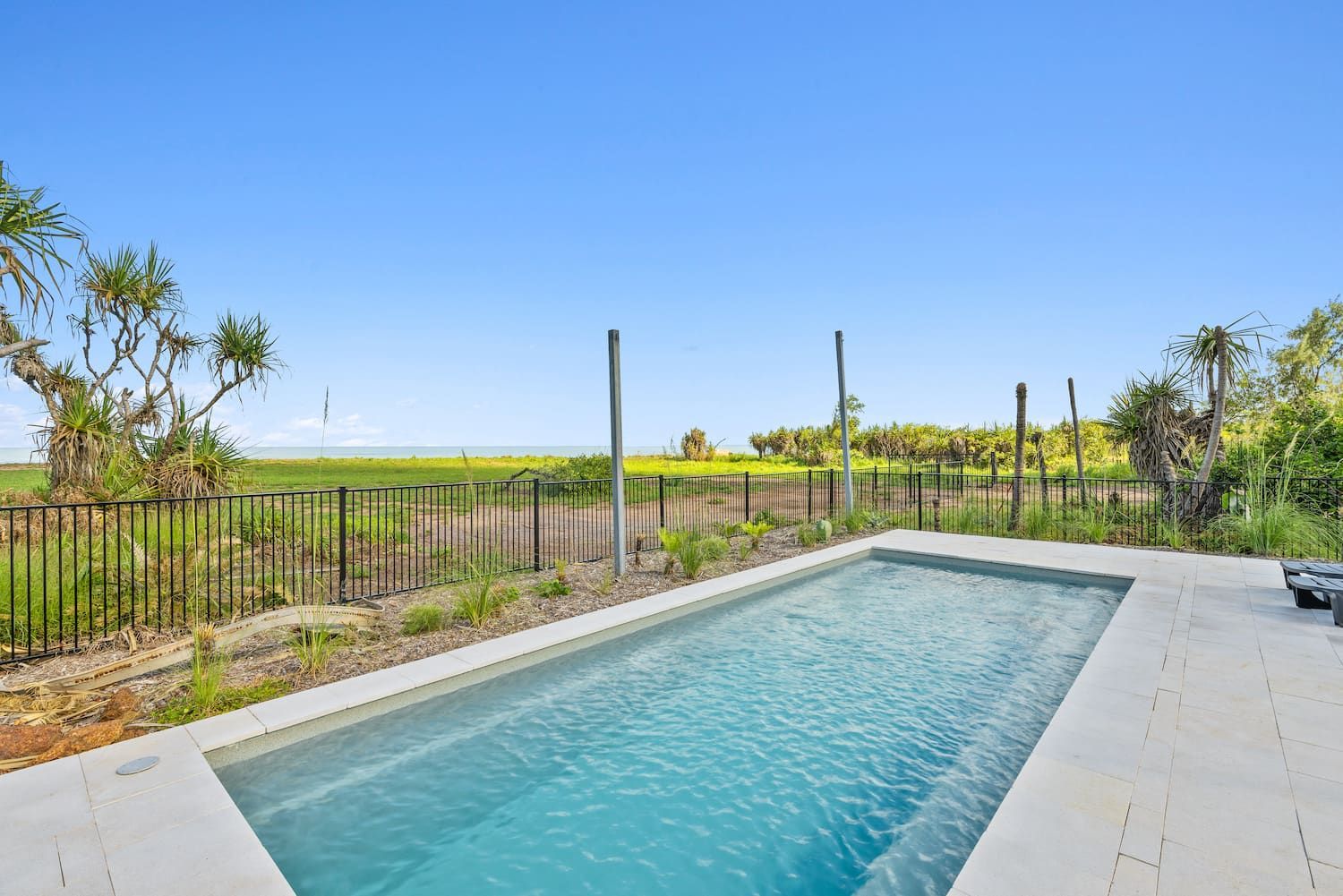 A Large Swimming Pool is Surrounded by a Fence and a Field — Pooltech NT In Alawa, NT