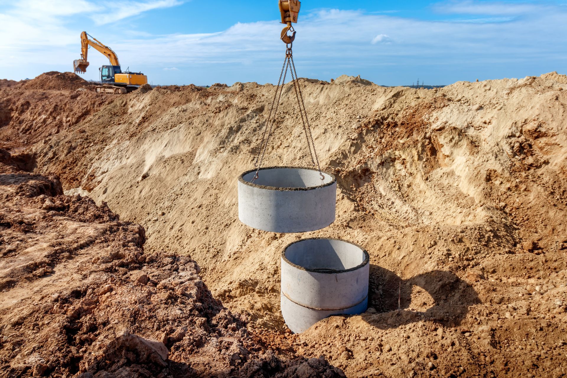Crane Lowering Concrete Rings Into an Excavation Pit — BC Earthmoving & Civil Construction in East Barron QLD
