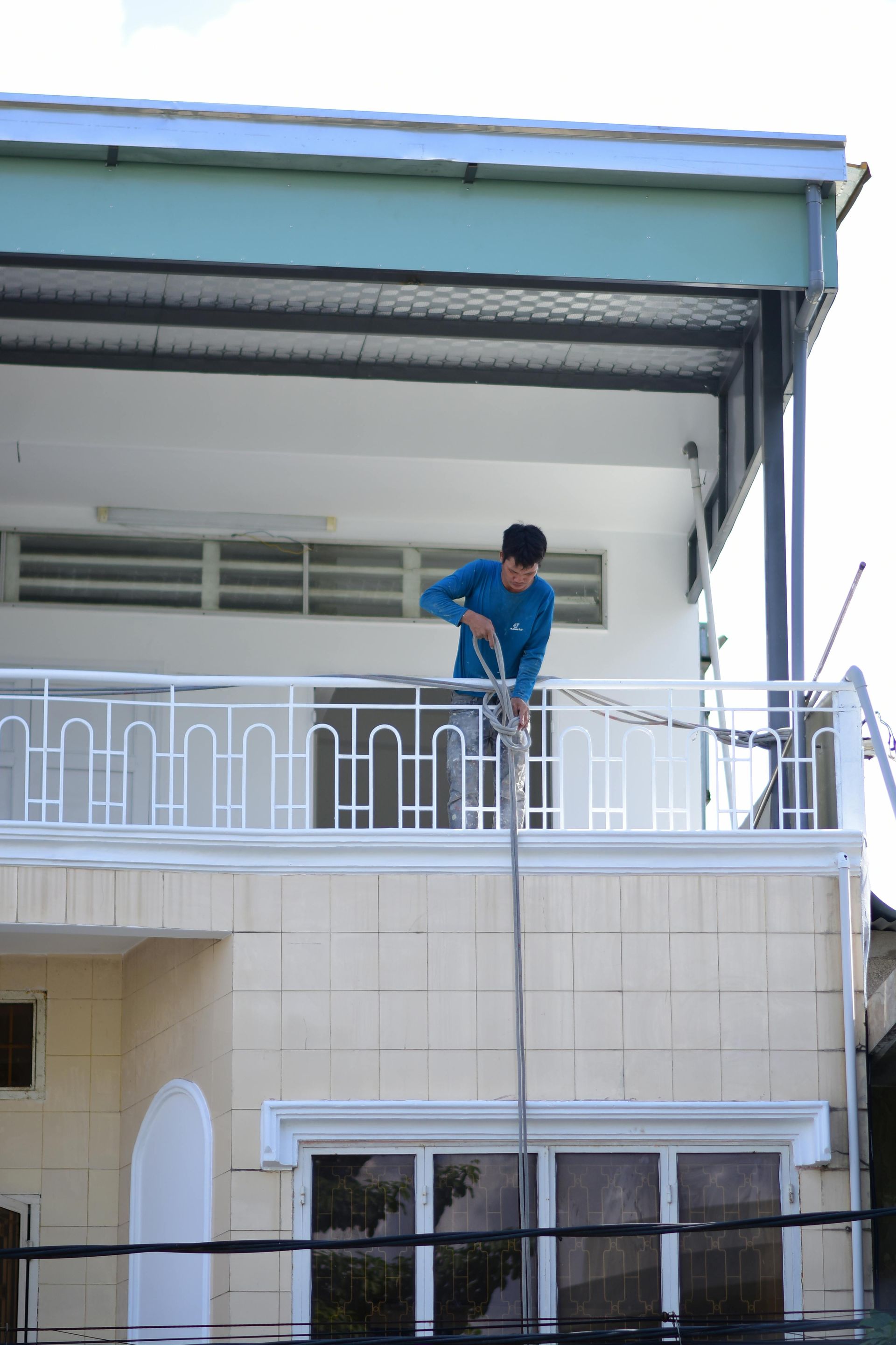 Woman in straw hat smiles, holding wine glass near a lake.