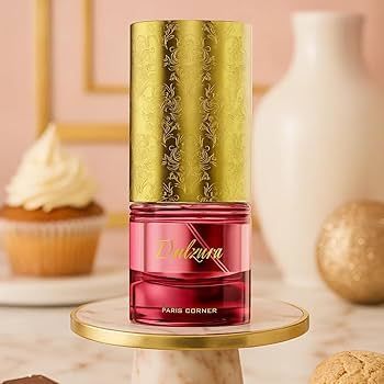 Parfumflesje met gouden dop, roze huls, label Paris Corner, op een marmeren voetstuk. Cupcake op de achtergrond.