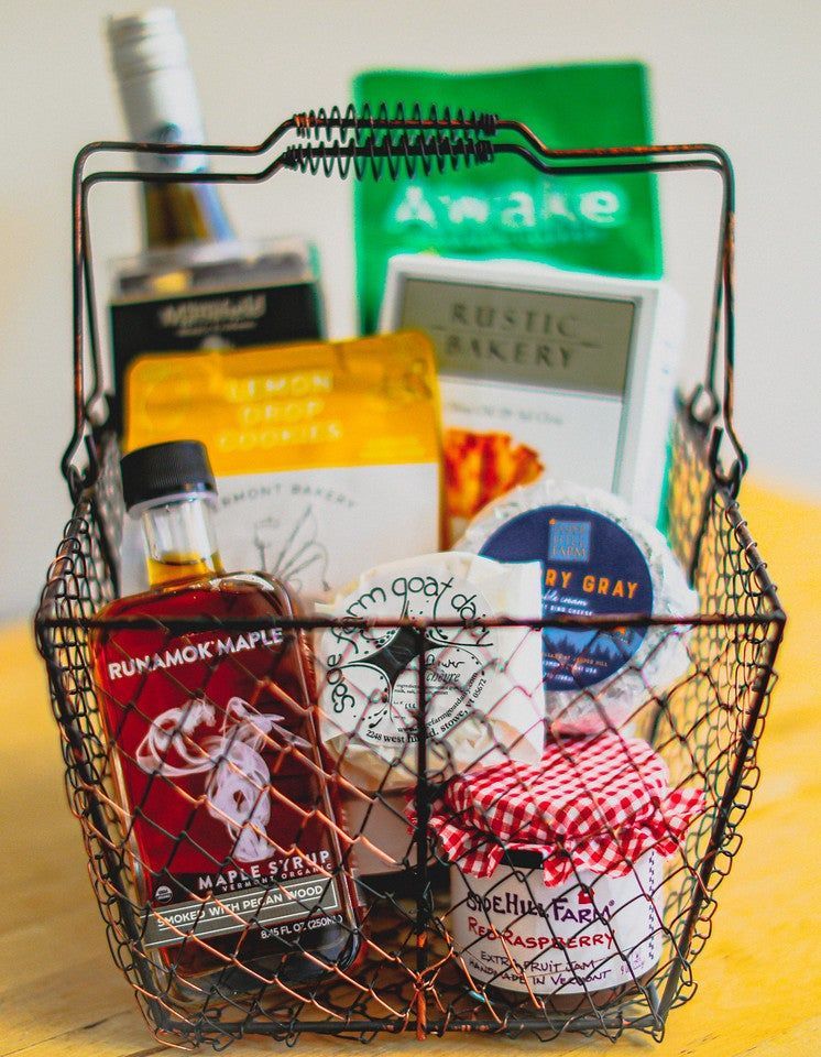 A basket filled with food and a bottle of maple syrup