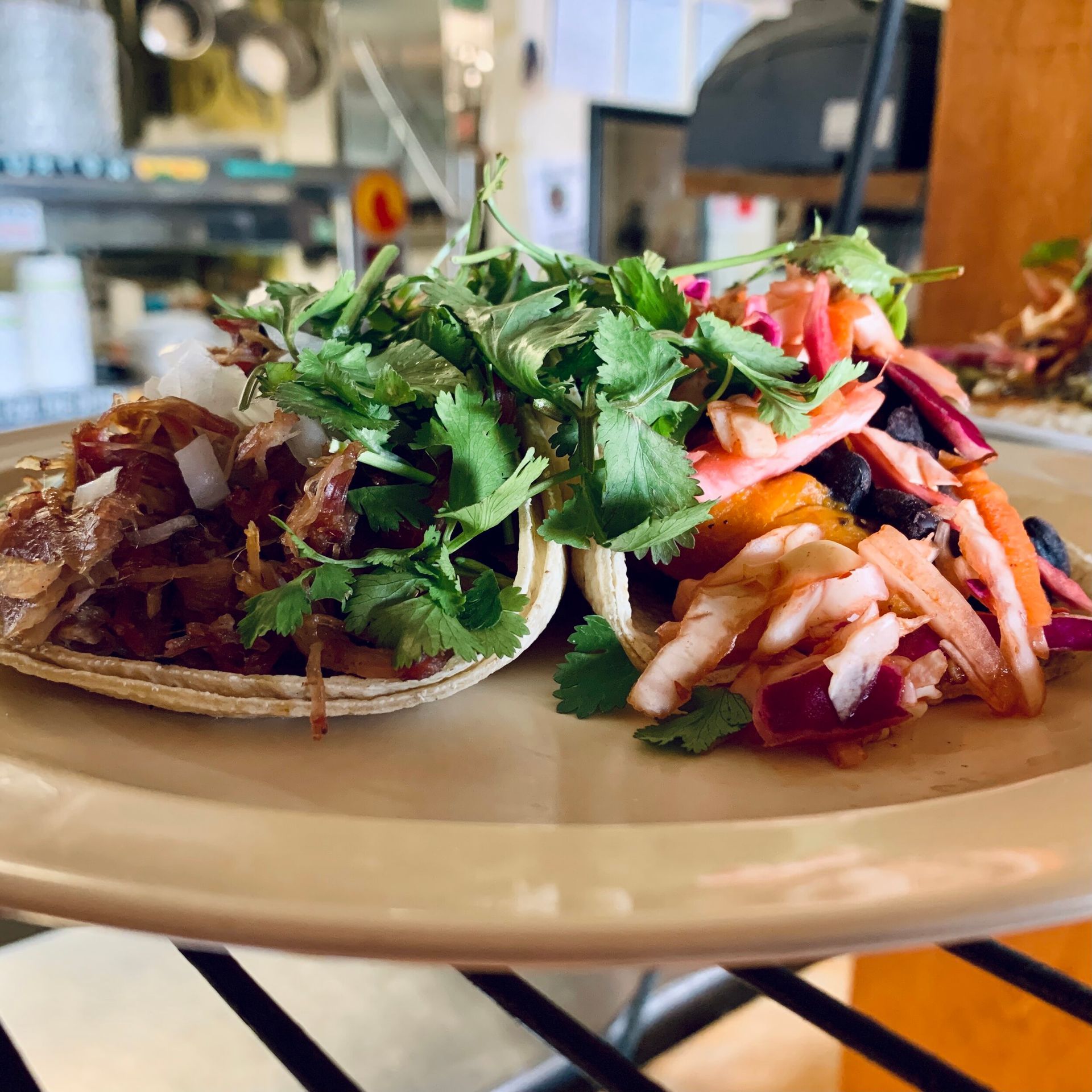 Two tacos with meat and vegetables on a plate