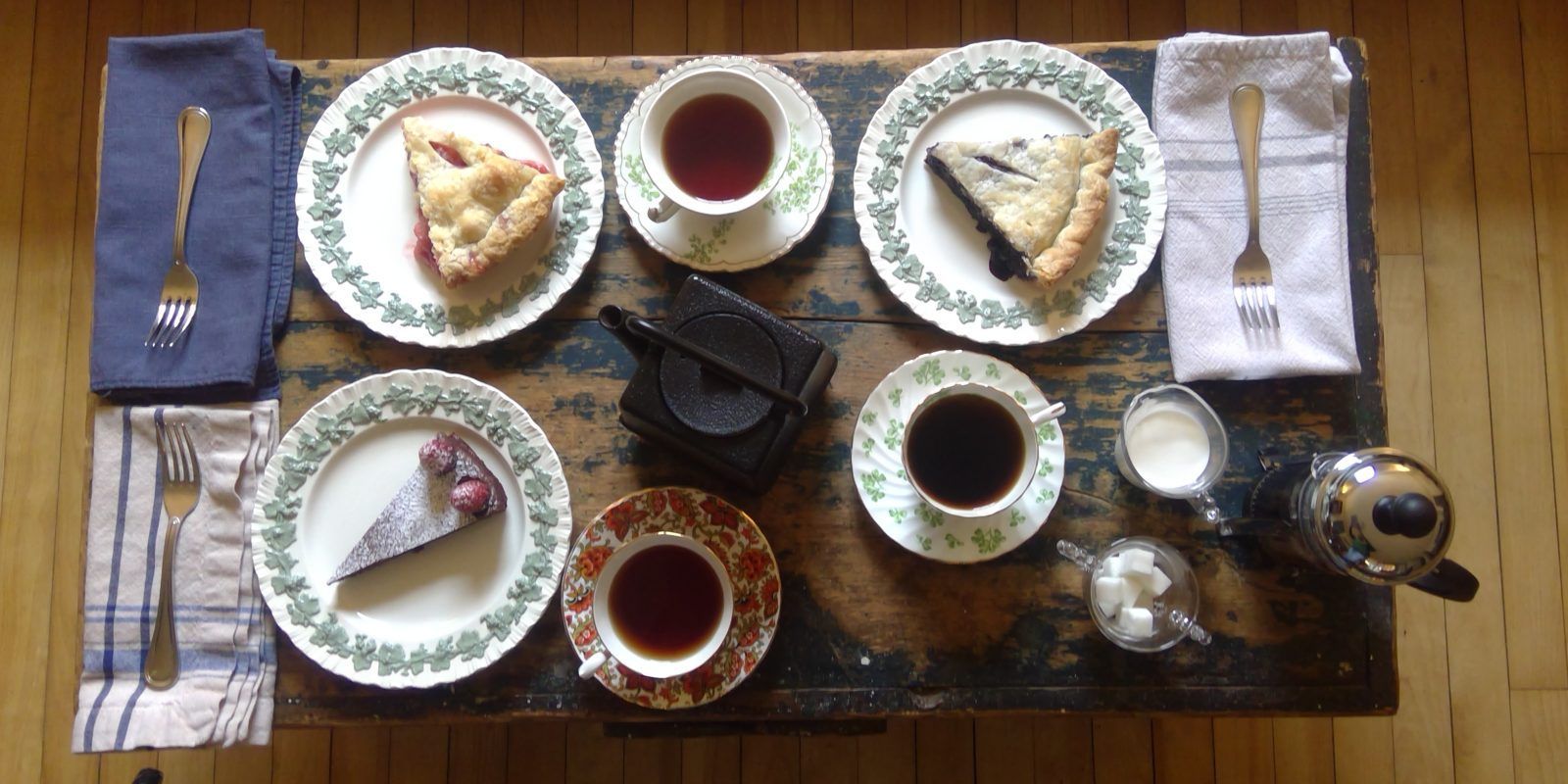 A table topped with plates of food and cups of tea