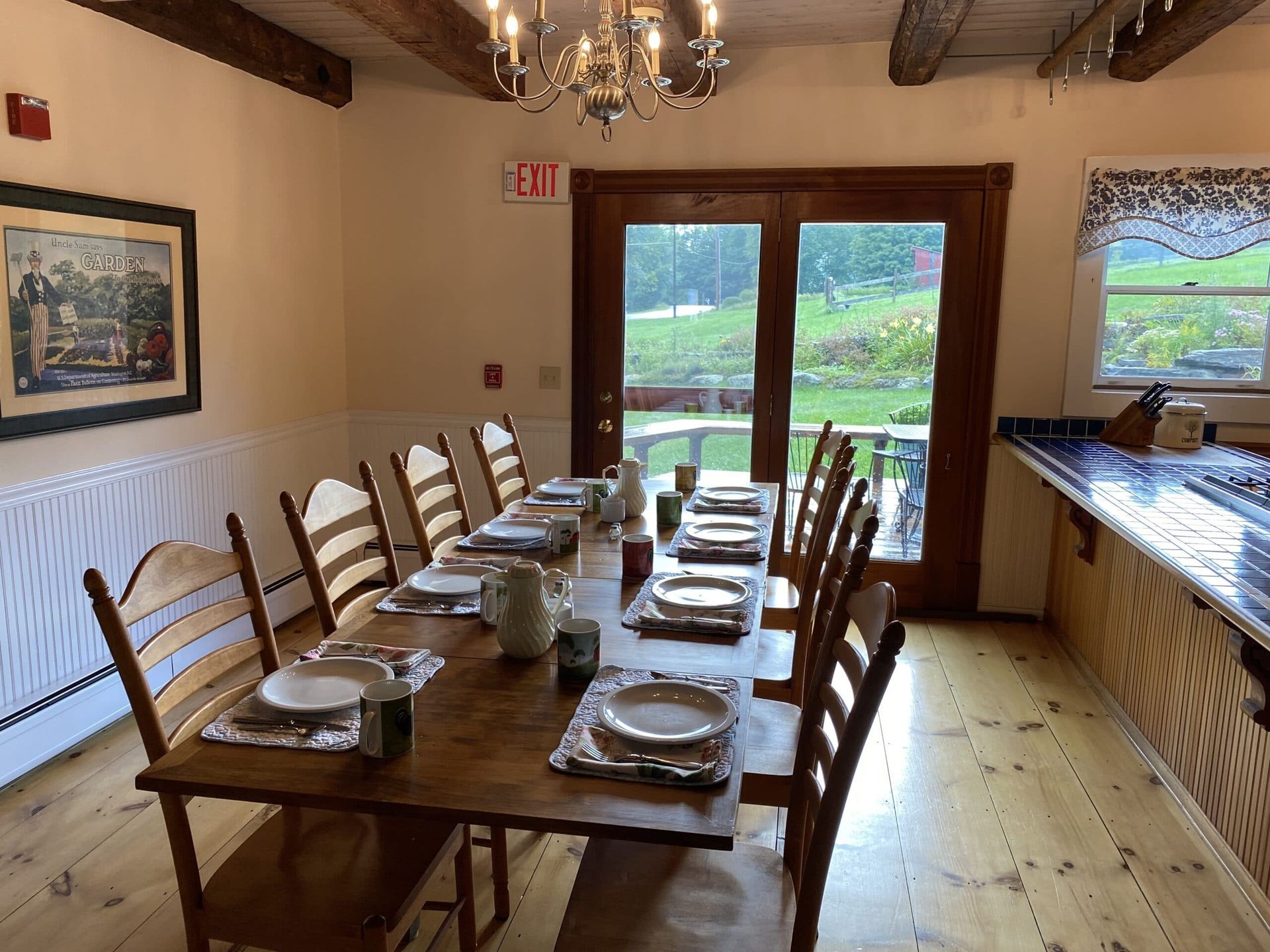 A dining room with a long table and chairs and plates on it.