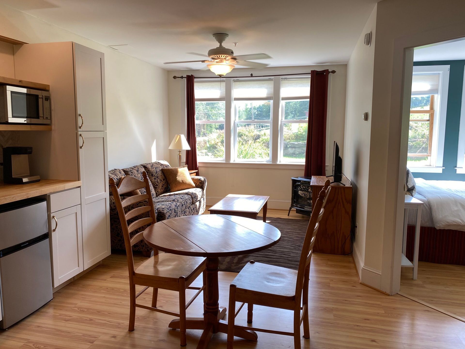 A living room with a table and chairs and a ceiling fan