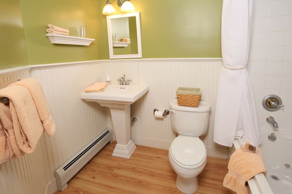 A bathroom with a toilet , sink and bathtub.