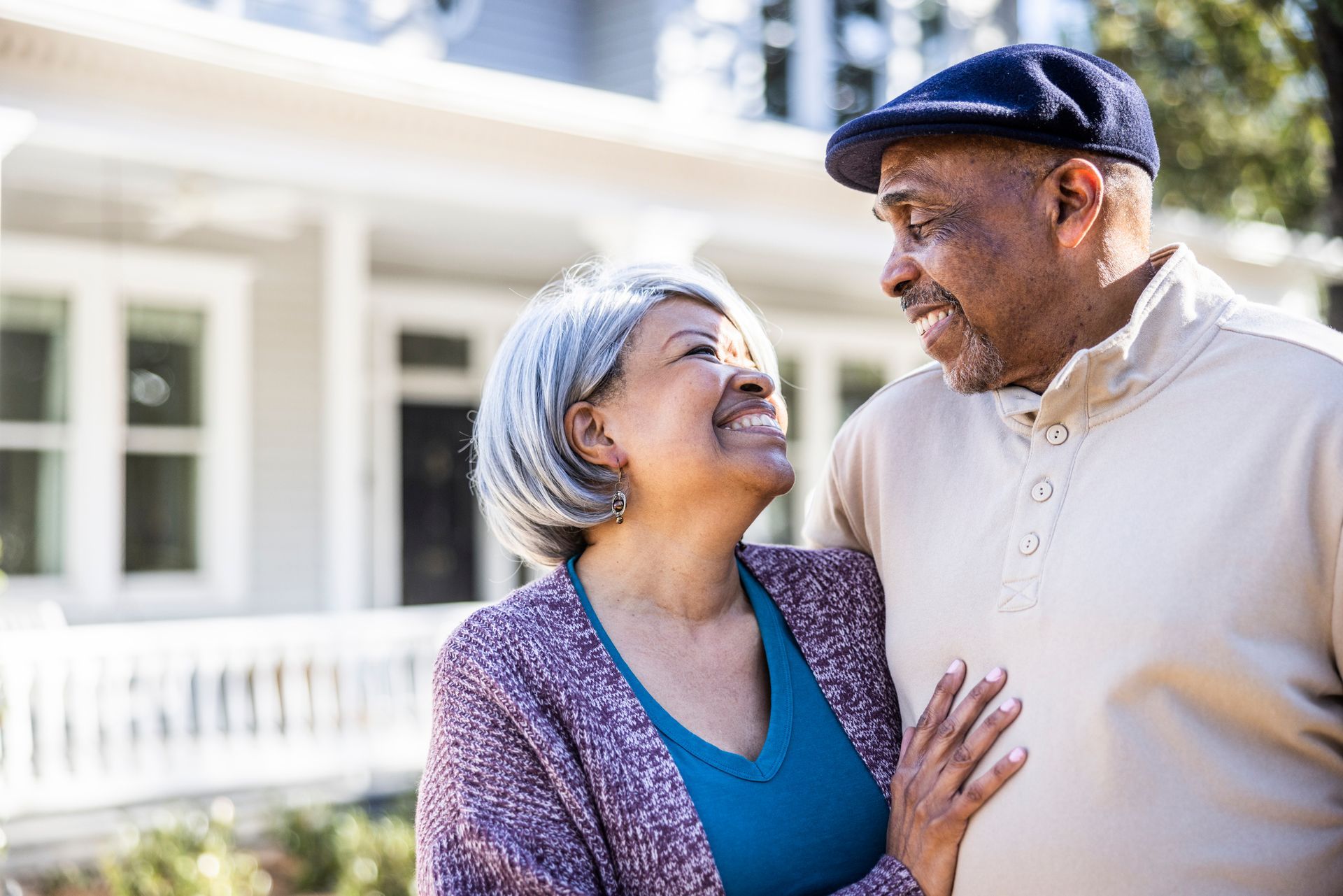 A man is hugging a woman who is wearing glasses.