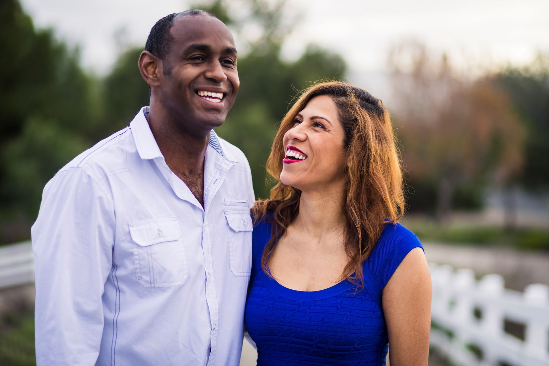 A man and a woman are standing next to each other and smiling.