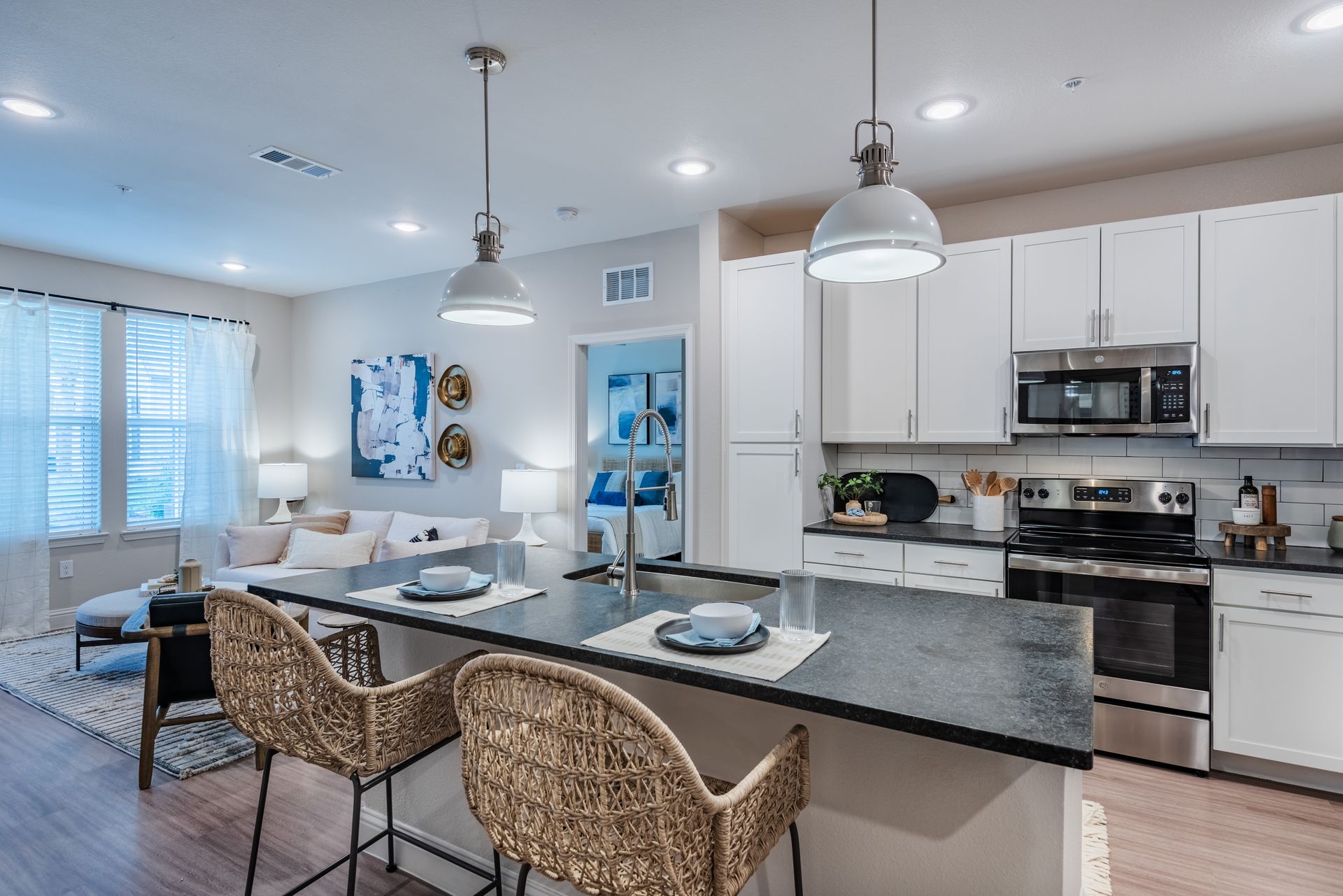 A kitchen with white cabinets , stainless steel appliances and a large island at Livano Kemah.
