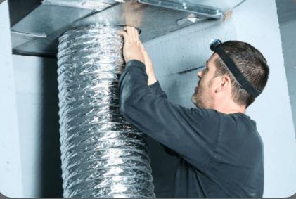 Worker cleaning air duct