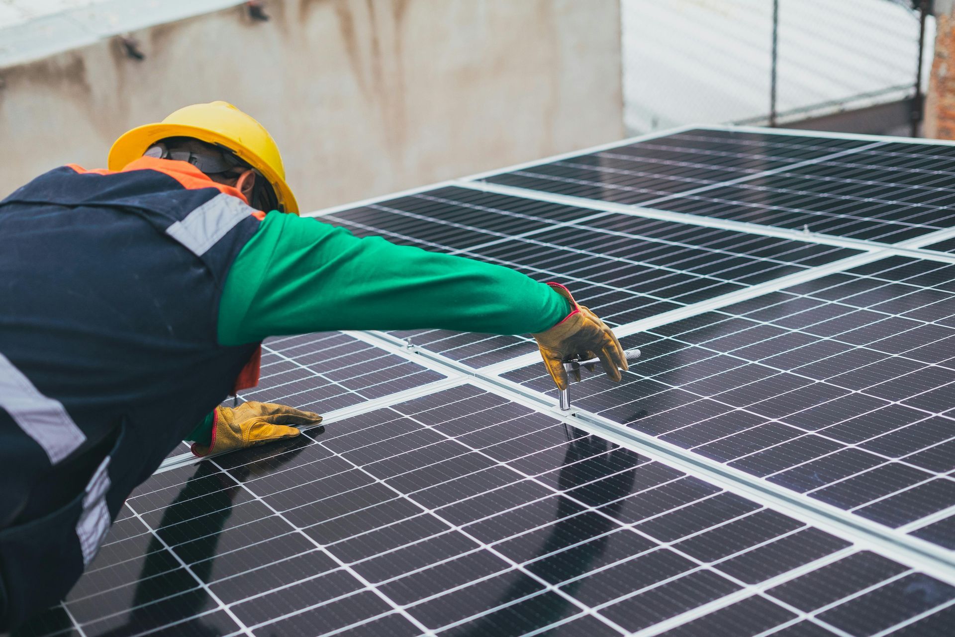 A man is working on a solar panel on the roof of a building.