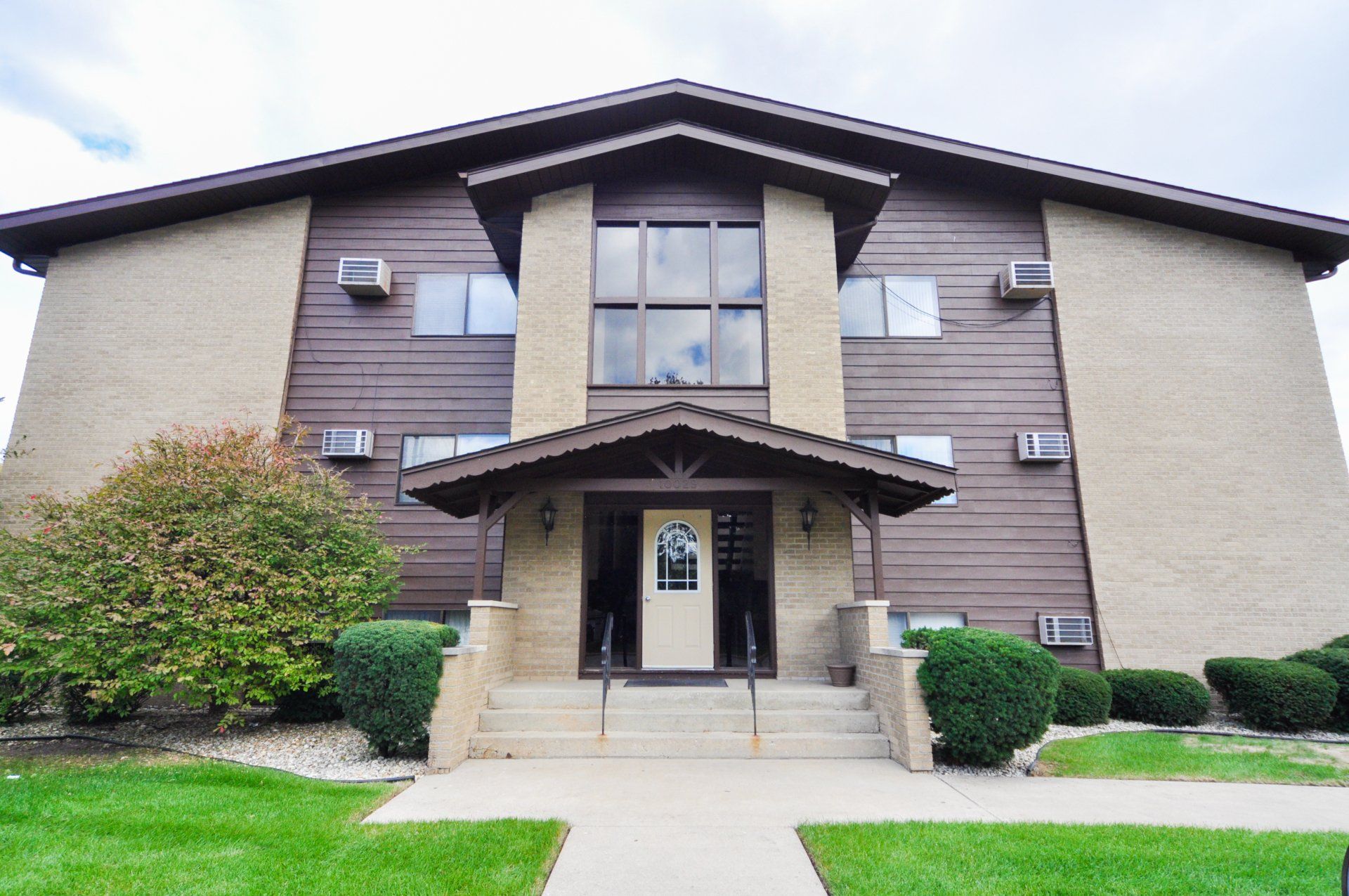 A large apartment building with a porch and stairs