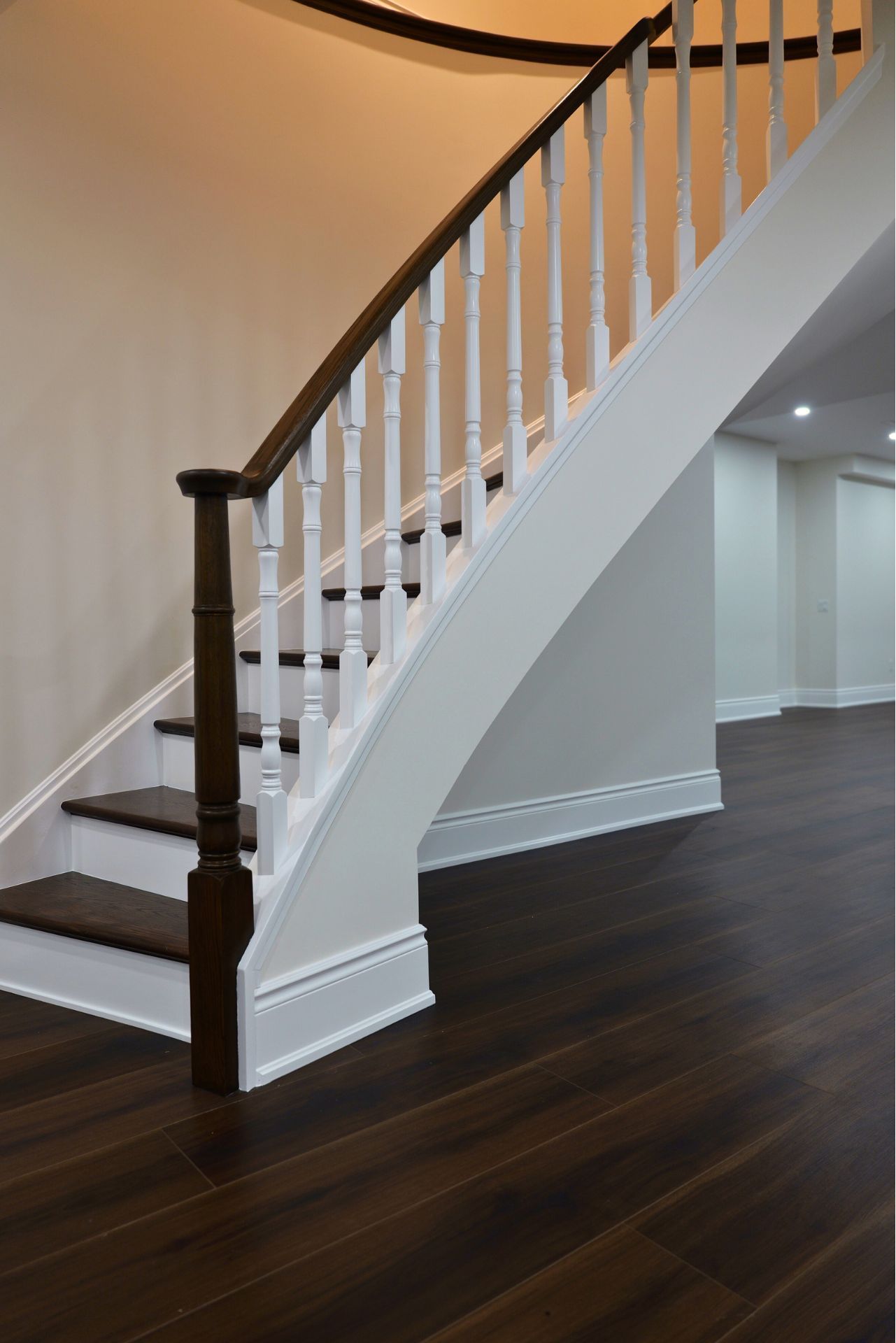 Dark wood staircase with white balusters and trim.