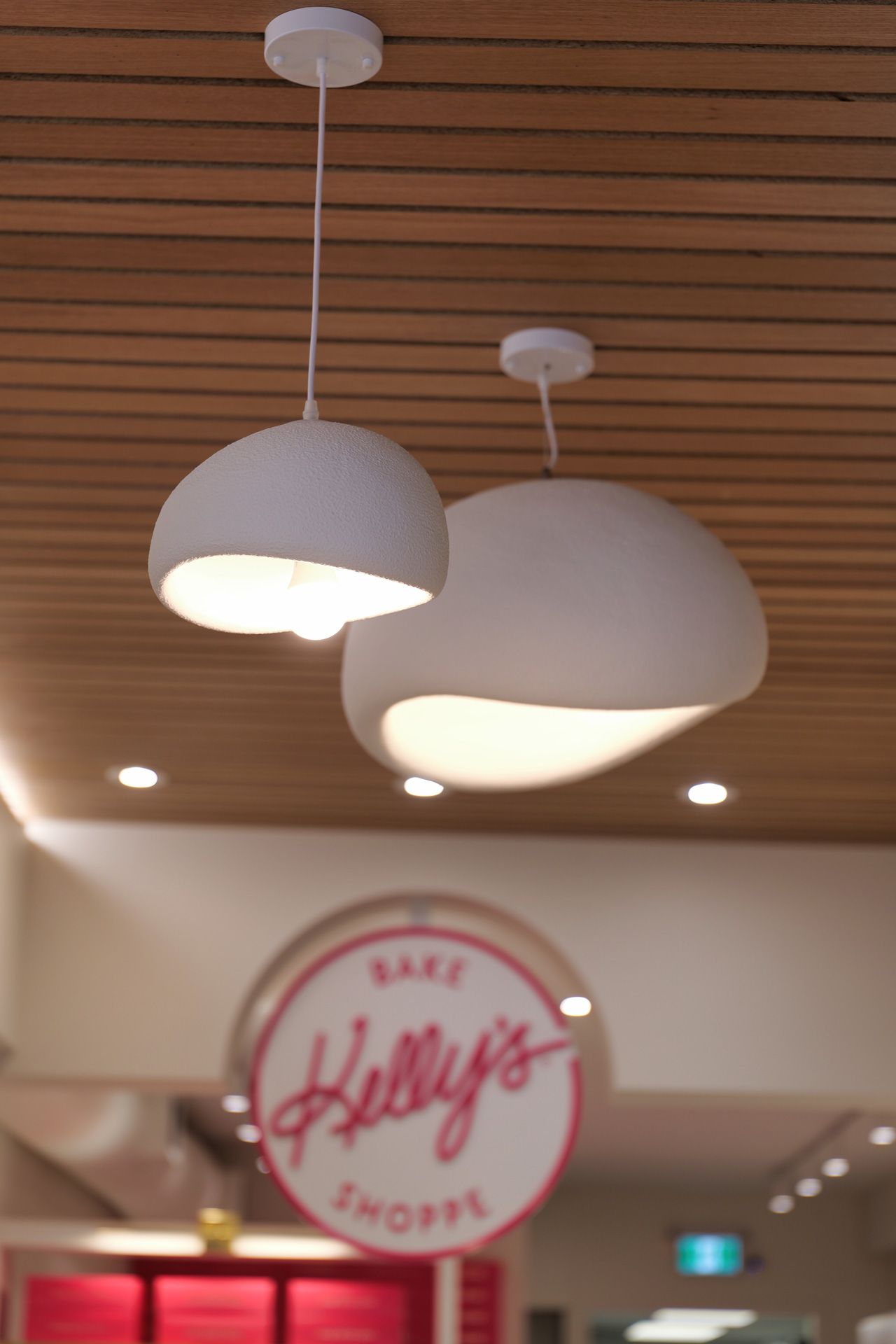 Two white pendant lights above a bakery sign that says