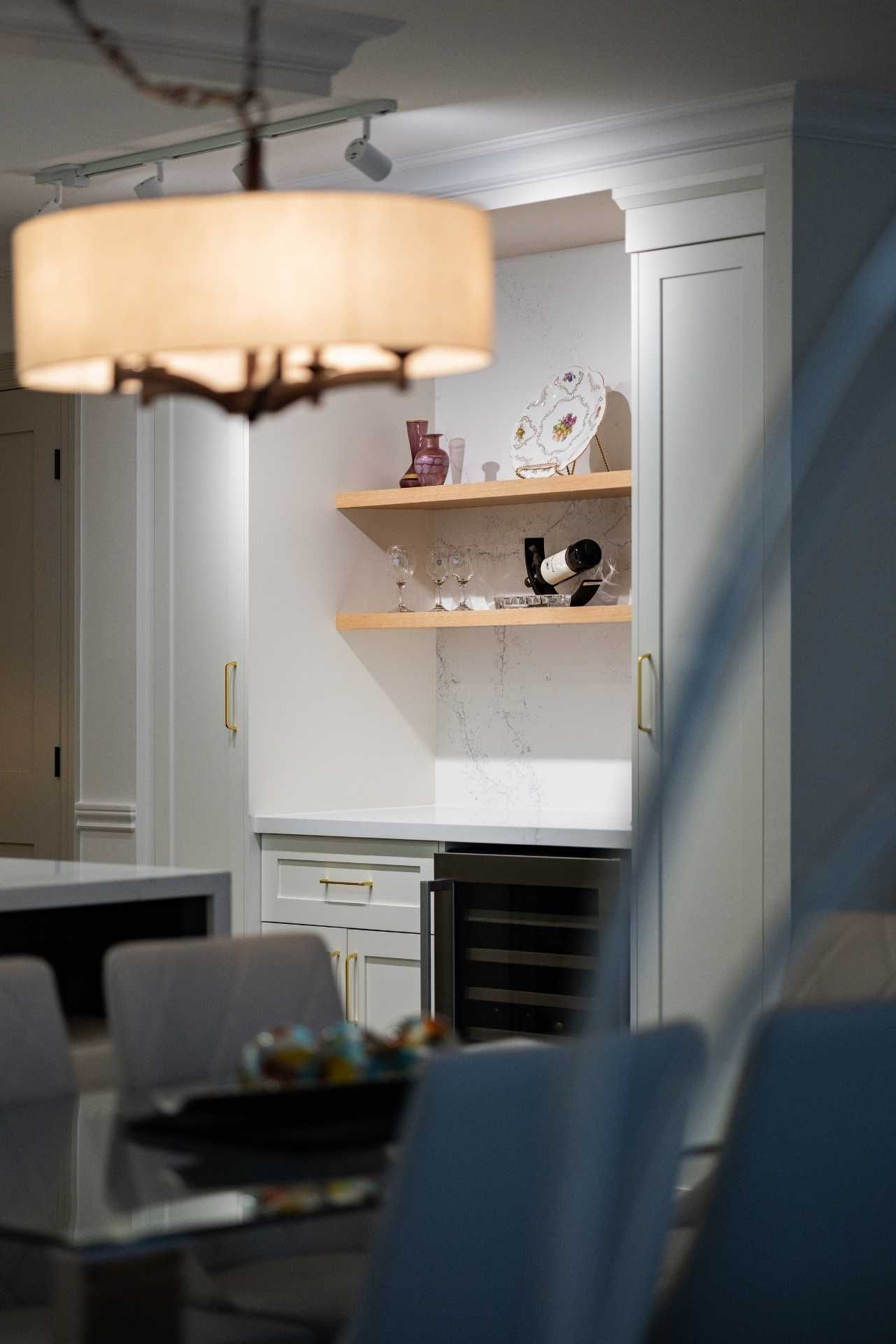 Dining room with built-in wine storage, white cabinetry, and a chandelier; table set for dining.