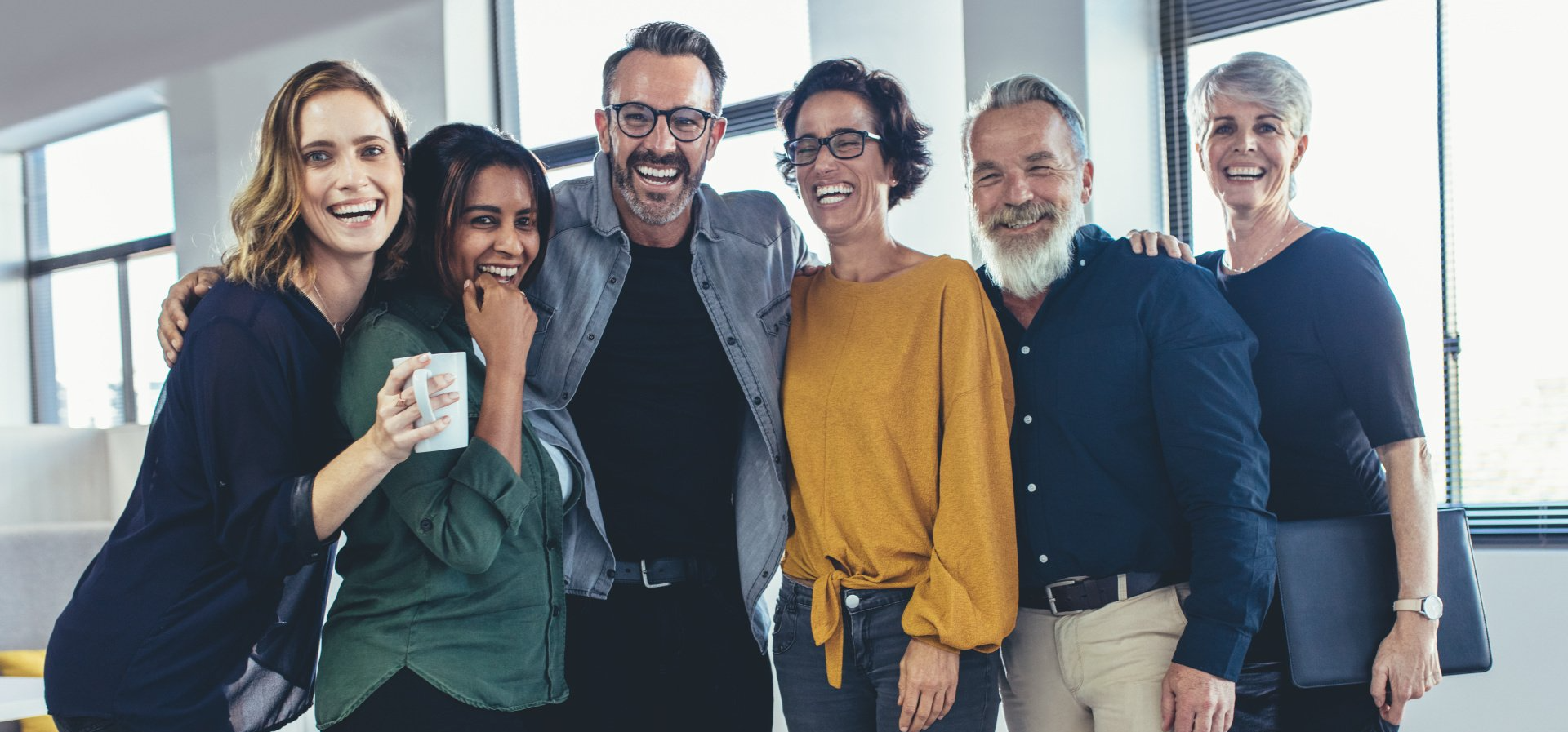 A group of people are posing for a picture together in an office.